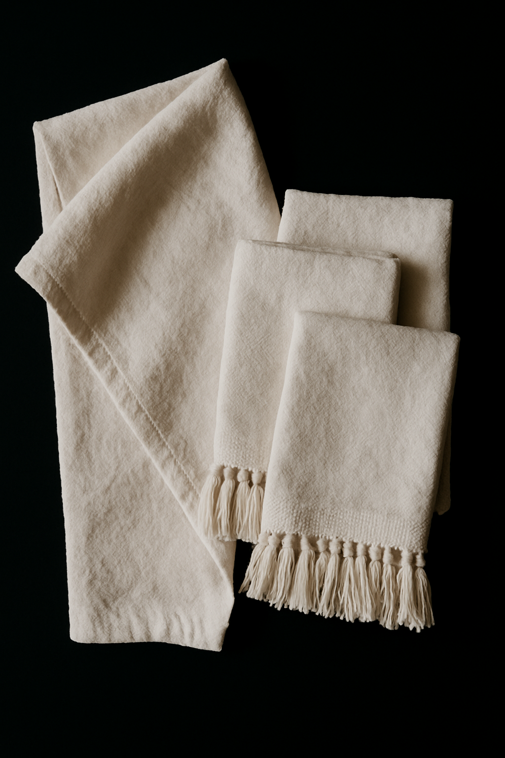 hite Turkish cotton hand towels arranged on a black background.”