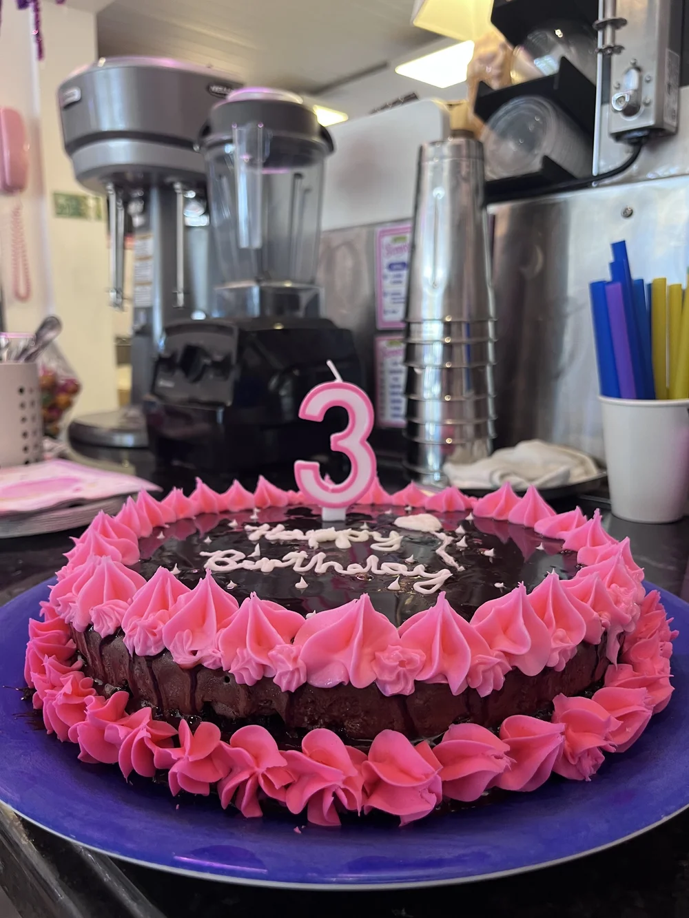 Chocolate ice cream birthday cake with bright pink piping