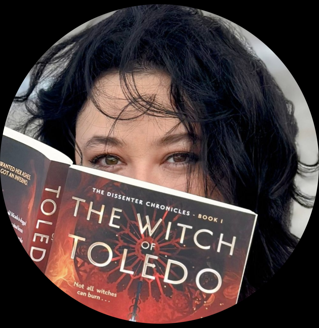Photo of a dark-haired woman, her face half-covered by her book: The Witch of Toledo.