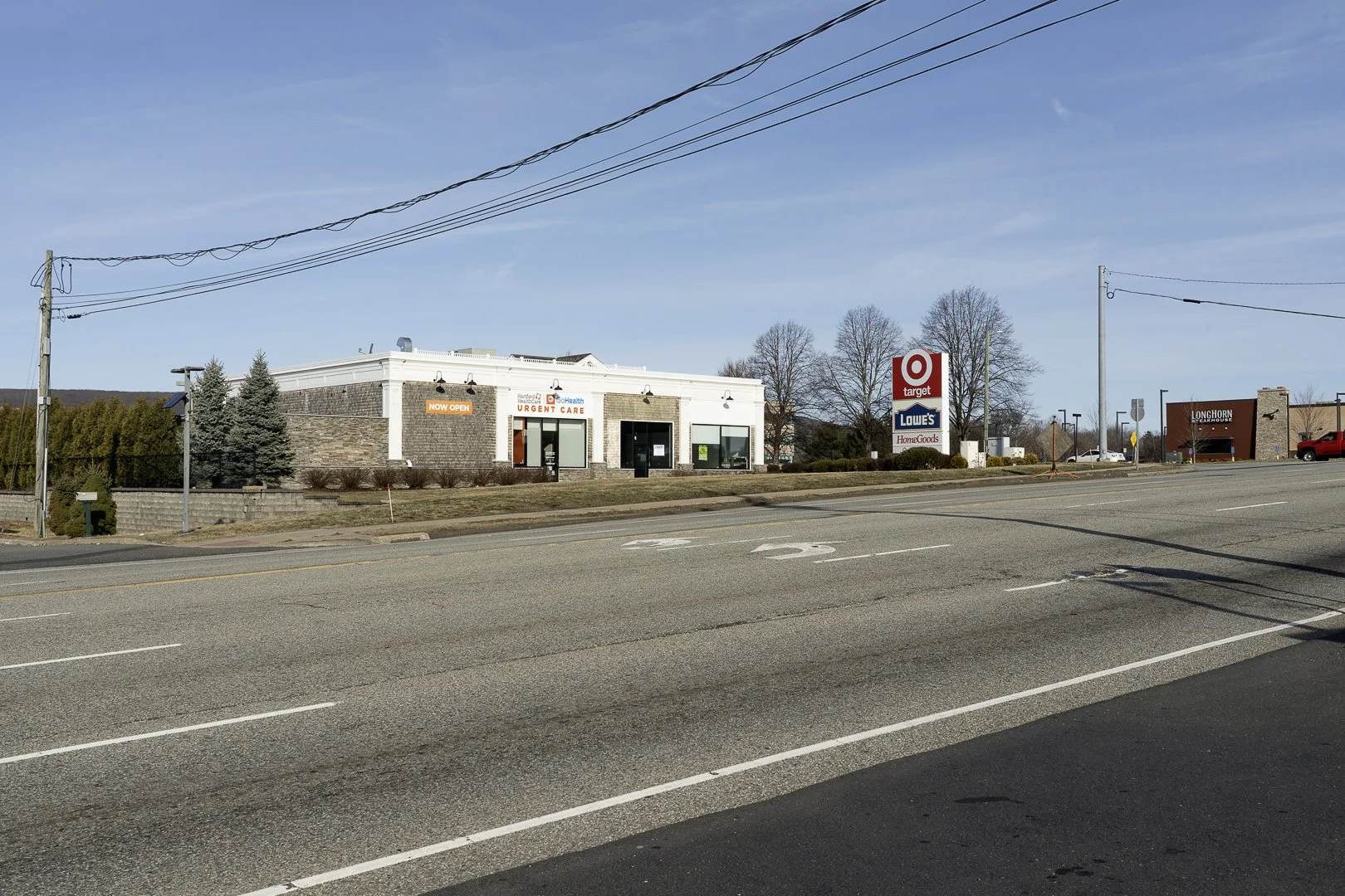 A street view with Target, Lowe's, and LongHorn Steakhouse stores visible. A sign indicates the Target store is now open, and there are few vehicles parked along the road.