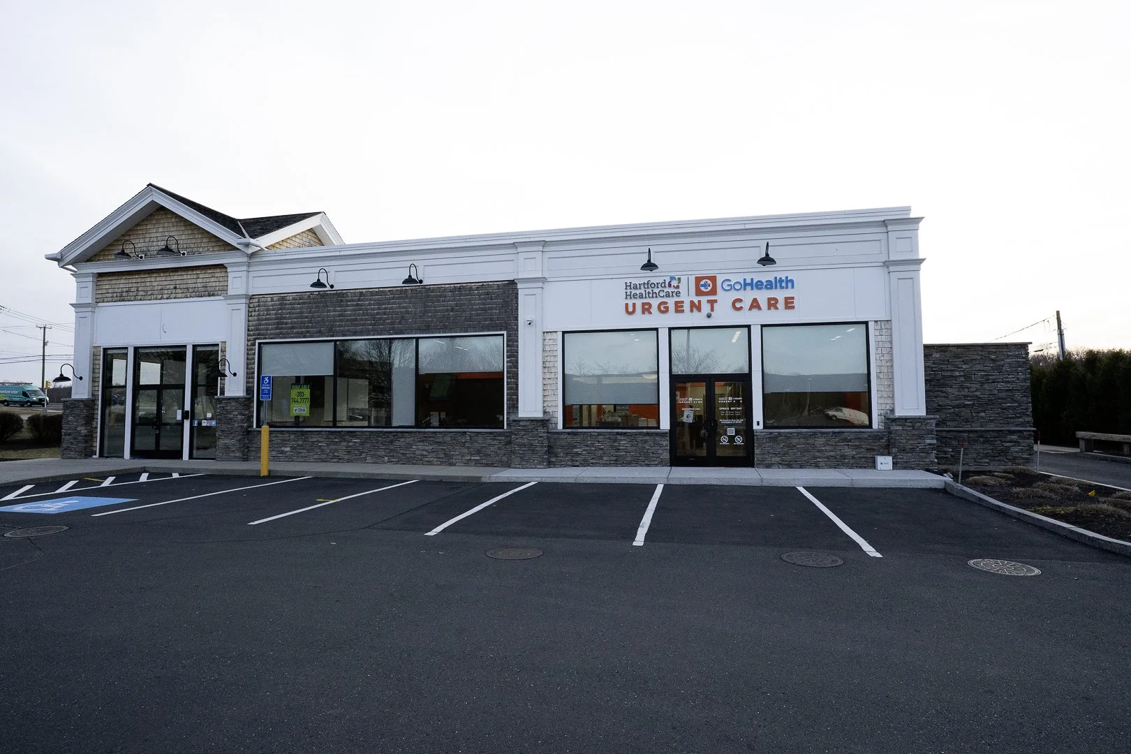 Exterior of a healthcare urgent care building with parking lot in front, labeled Hartford HealthCare GoHealth Urgent Care.