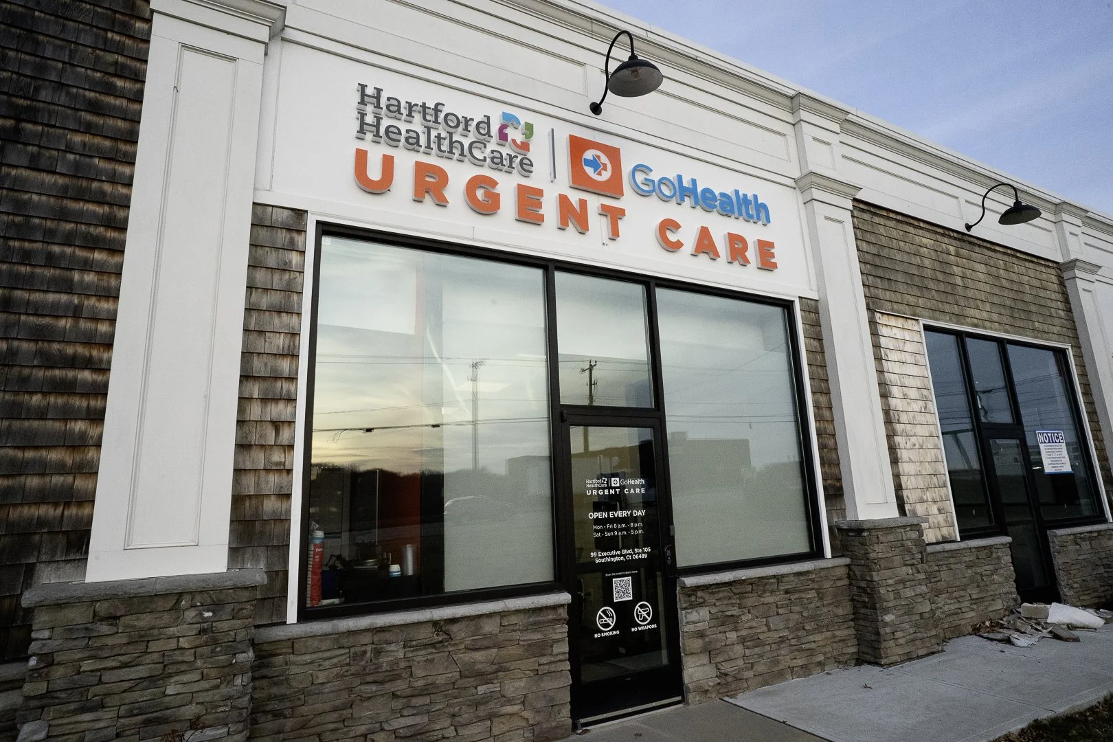 Exterior view of Hartford Healthcare GoHealth Urgent Care center with signage, large windows, and a stone and siding facade.