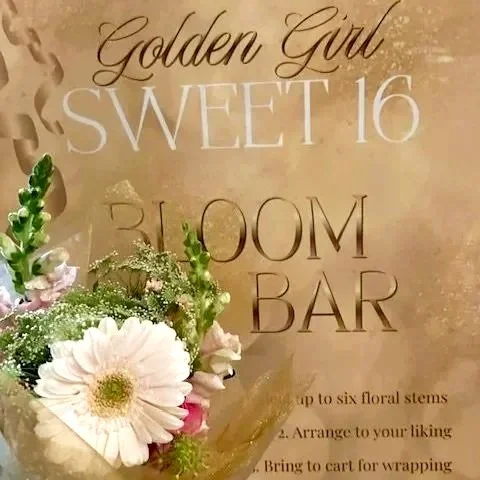 Sign for a sweet 16 birthday party flower bar, reading "Golden Girl Sweet 16 Bloom Bar."