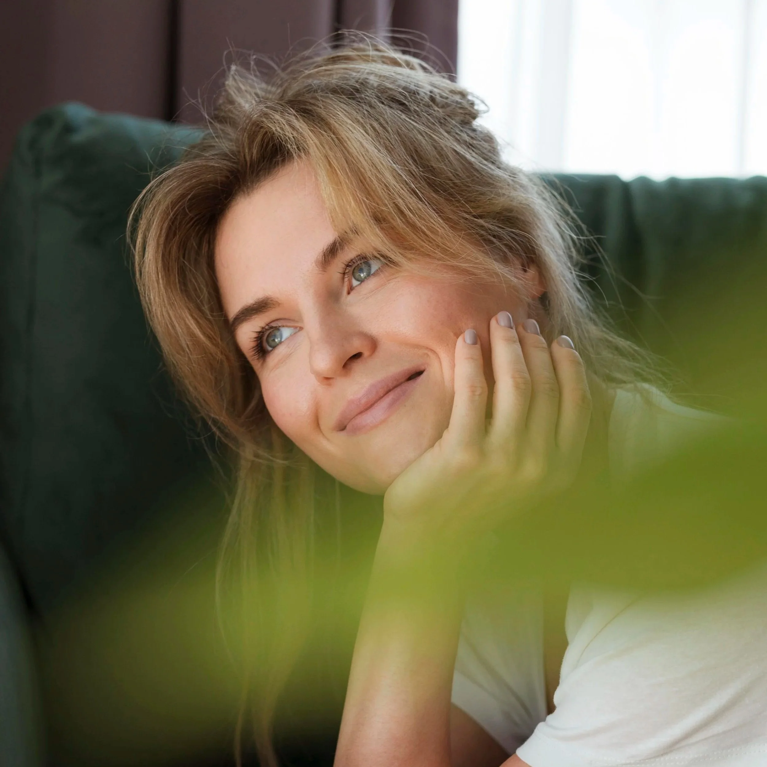 Woman resting her head on her hand in a quiet, reflective moment