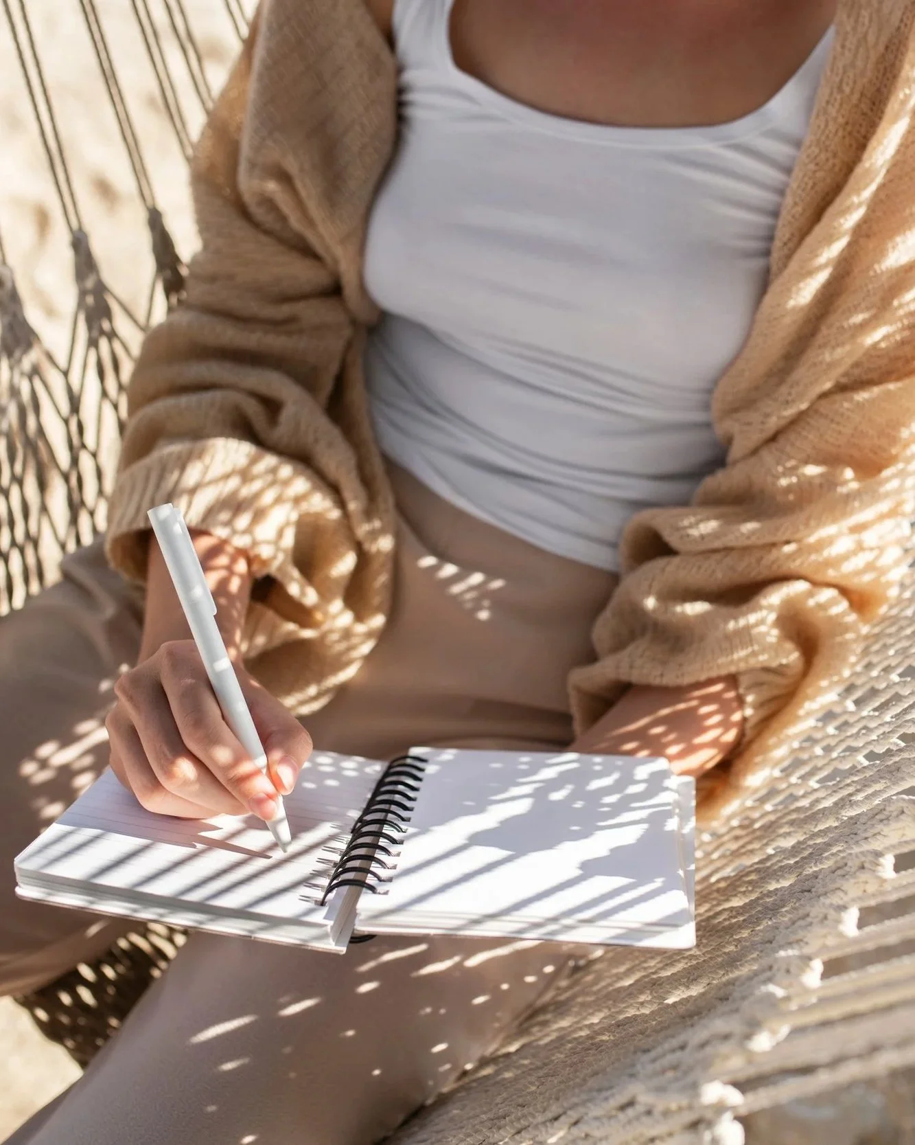 Person journaling outdoors in natural sunlight