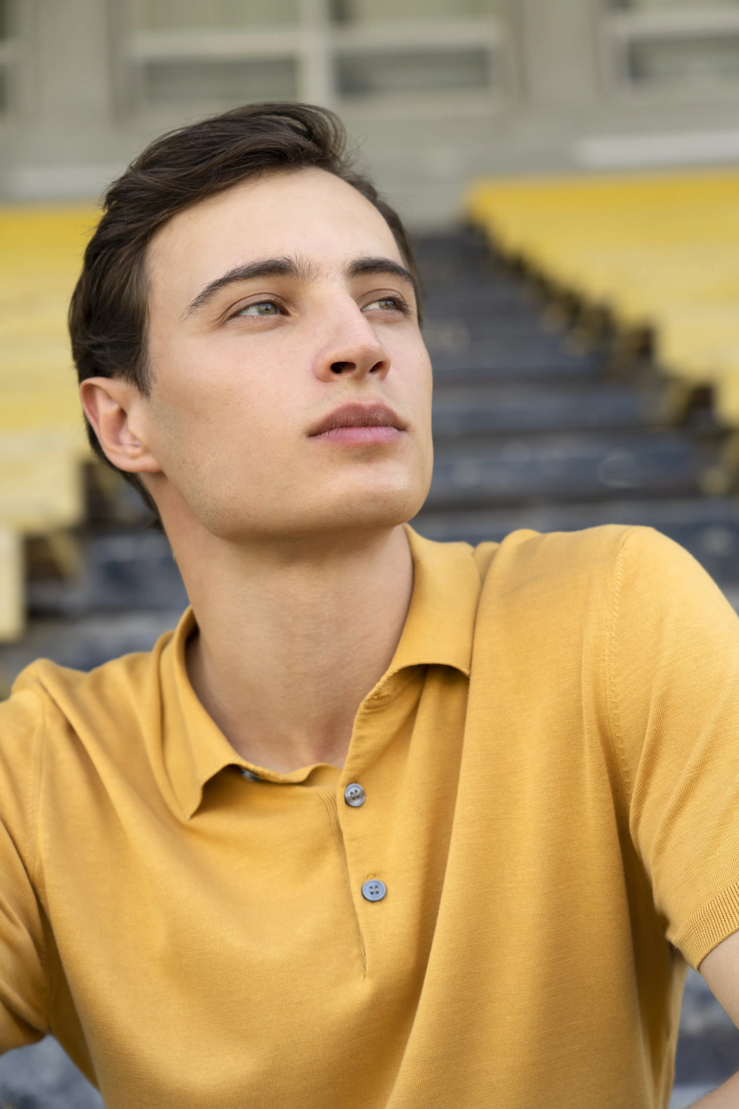 Close-up of a young man looking slightly upwards with a thoughtful expression