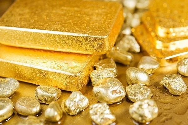 Lingots d'or et pépites d'or sur une surface dorée