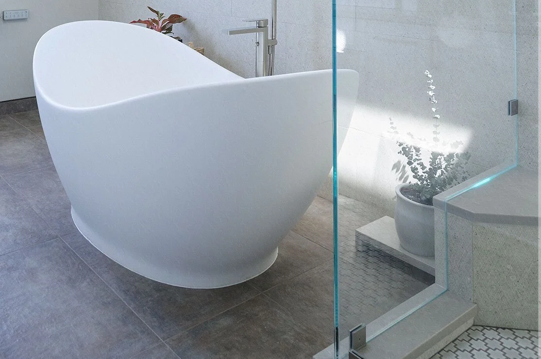 Clean, modern white bedroom with brass pendant light fixtures.