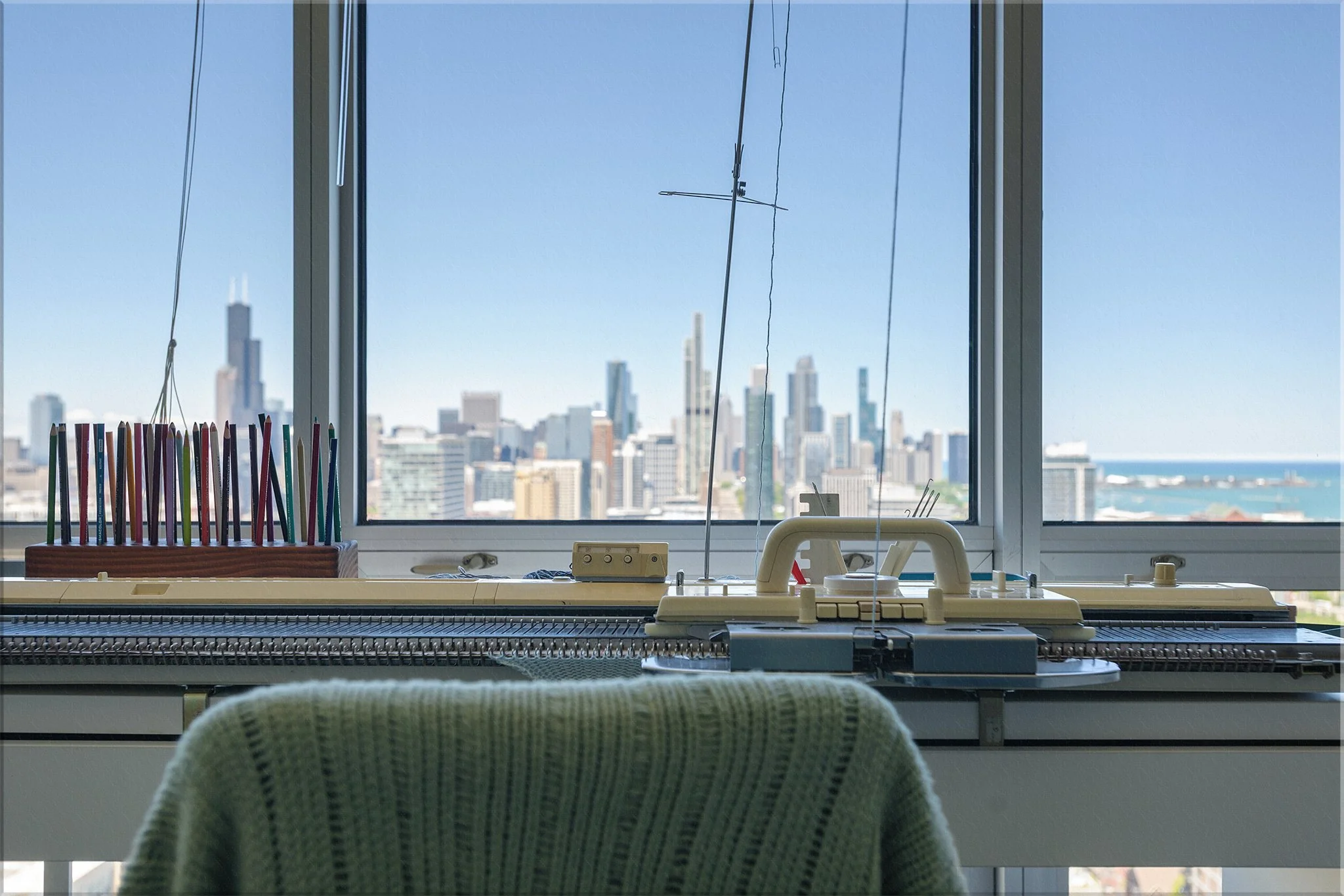 Knitting machine in home studio overlooking Chicago skyline.