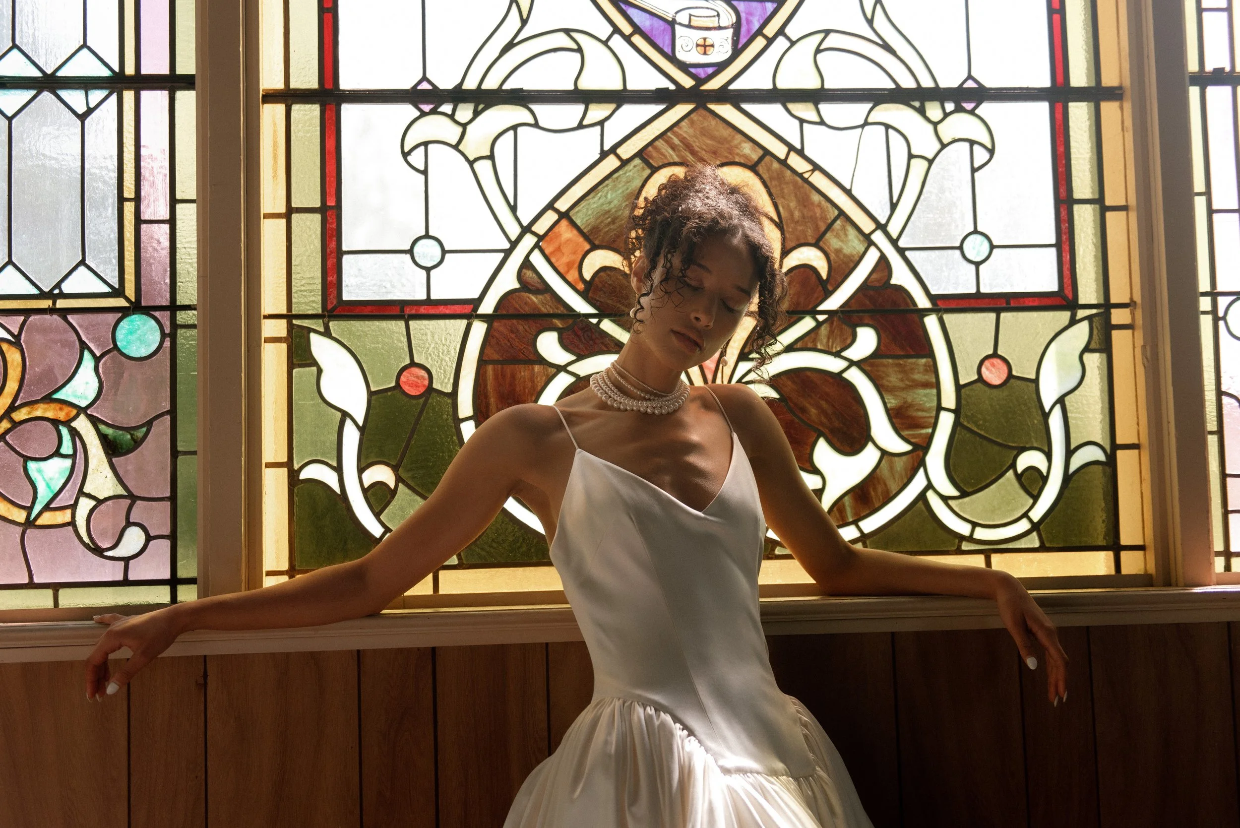 model posing during an editorial wedding shoot at a church with beautiful stained glass windows