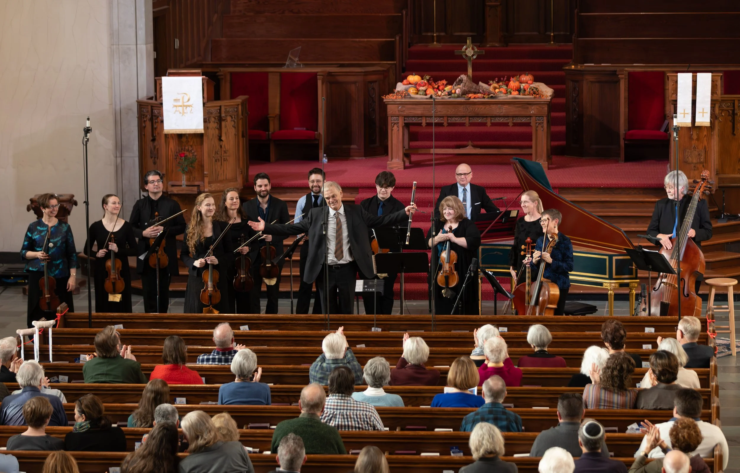 Musicians stand in front of an audience with their instruments