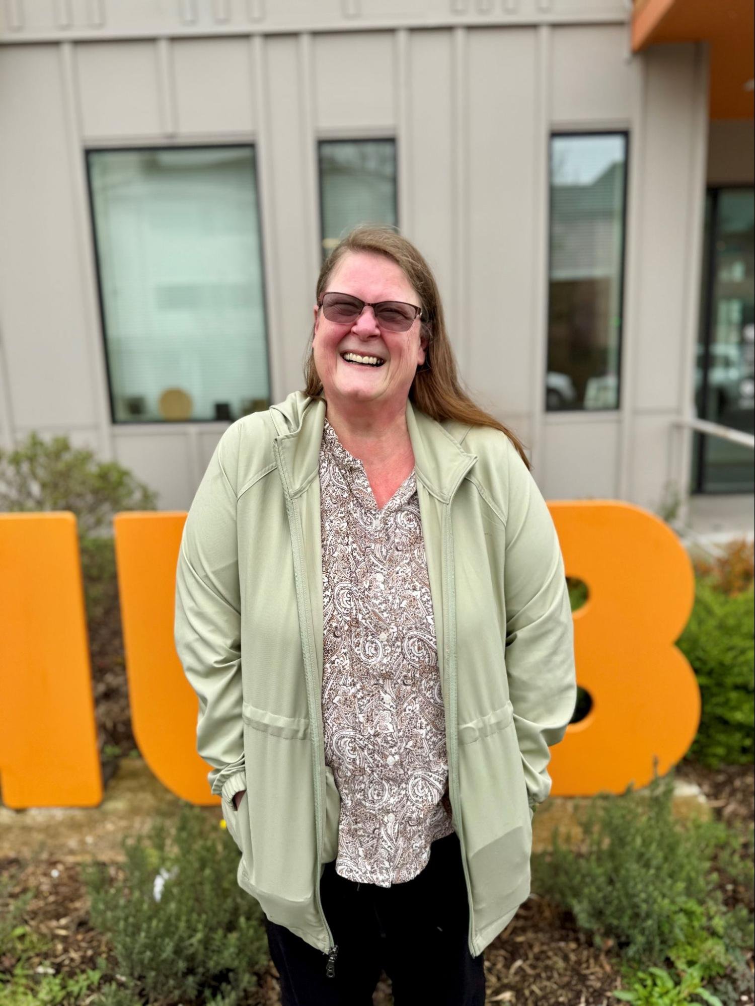 Woman smiling outside community resource center in Snohomish County, representing youth support and outreach services