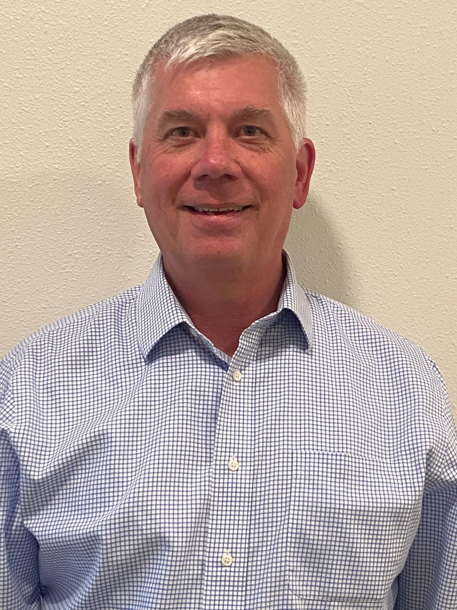 Board member with gray hair smiling in portrait against neutral background, Cocoon House Snohomish County