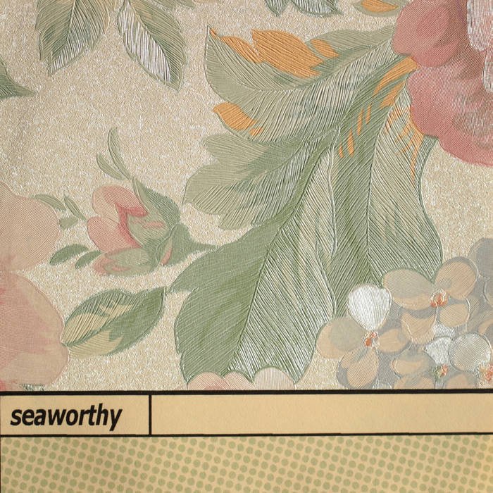 Close-up of vintage floral wallpaper with leaves, flowers, and berries, featuring soft pastel colors.
