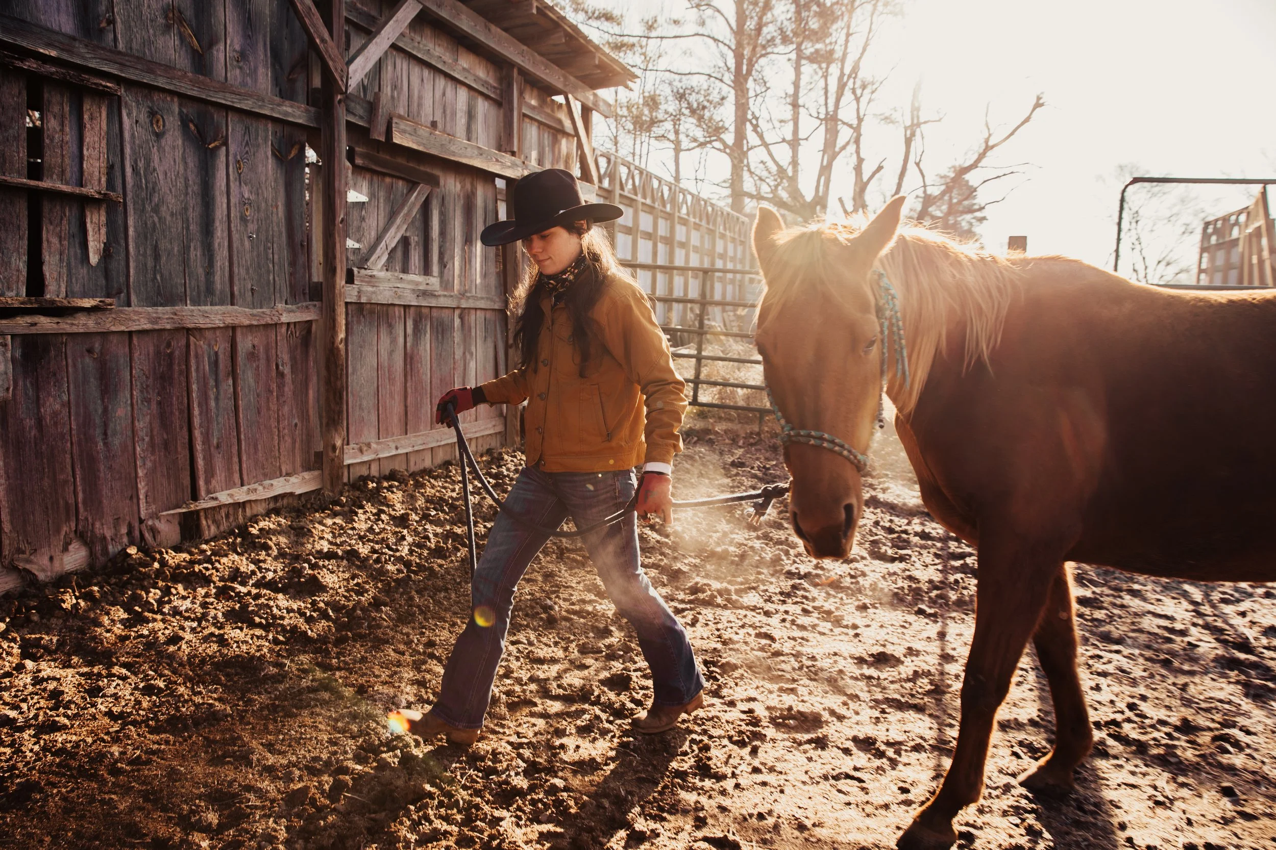 Ranch hand walking a horse beside a rustic barn in North Georgia