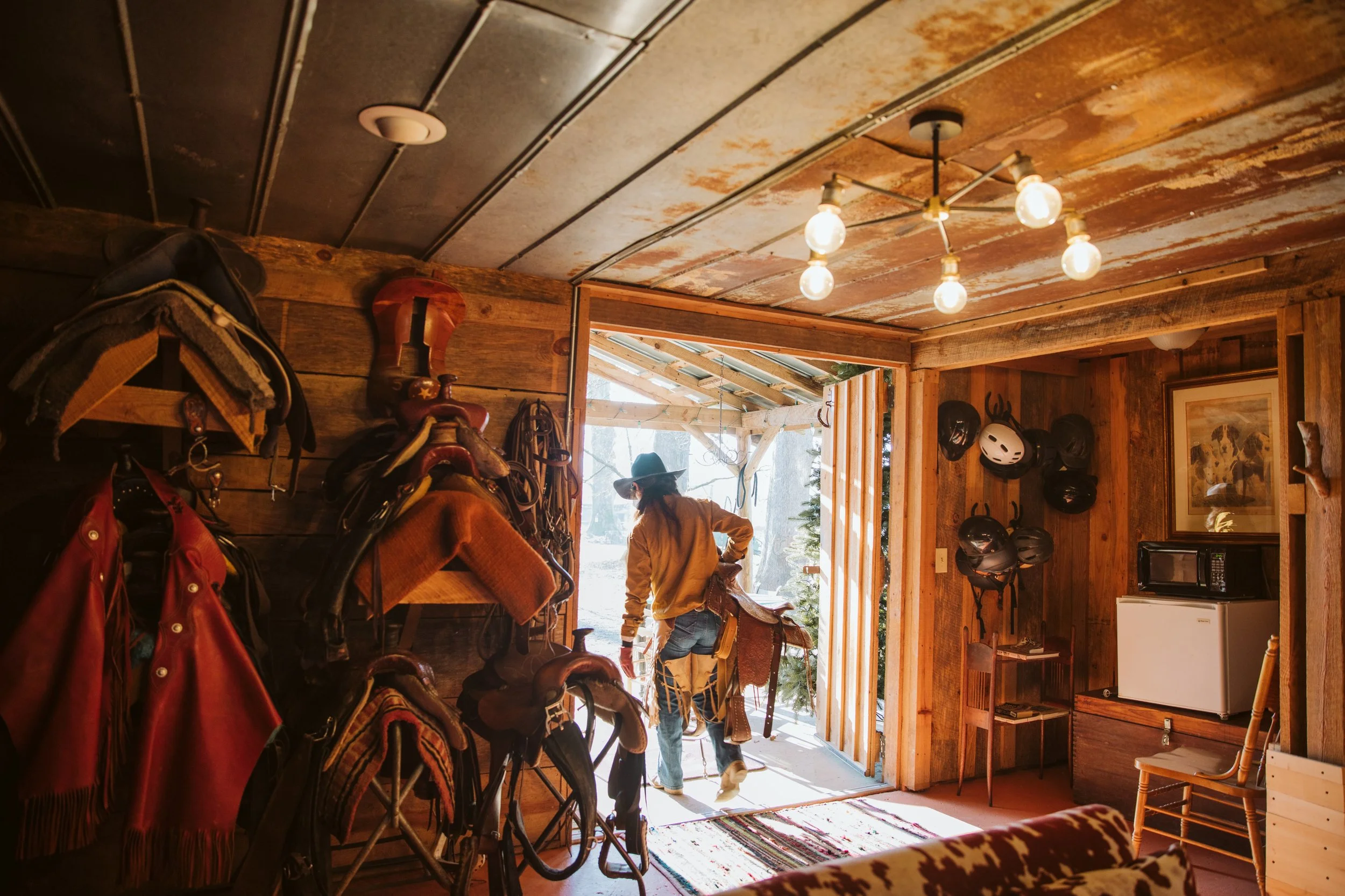 Rustic tack room with saddles and natural light at a North Georgia ranch