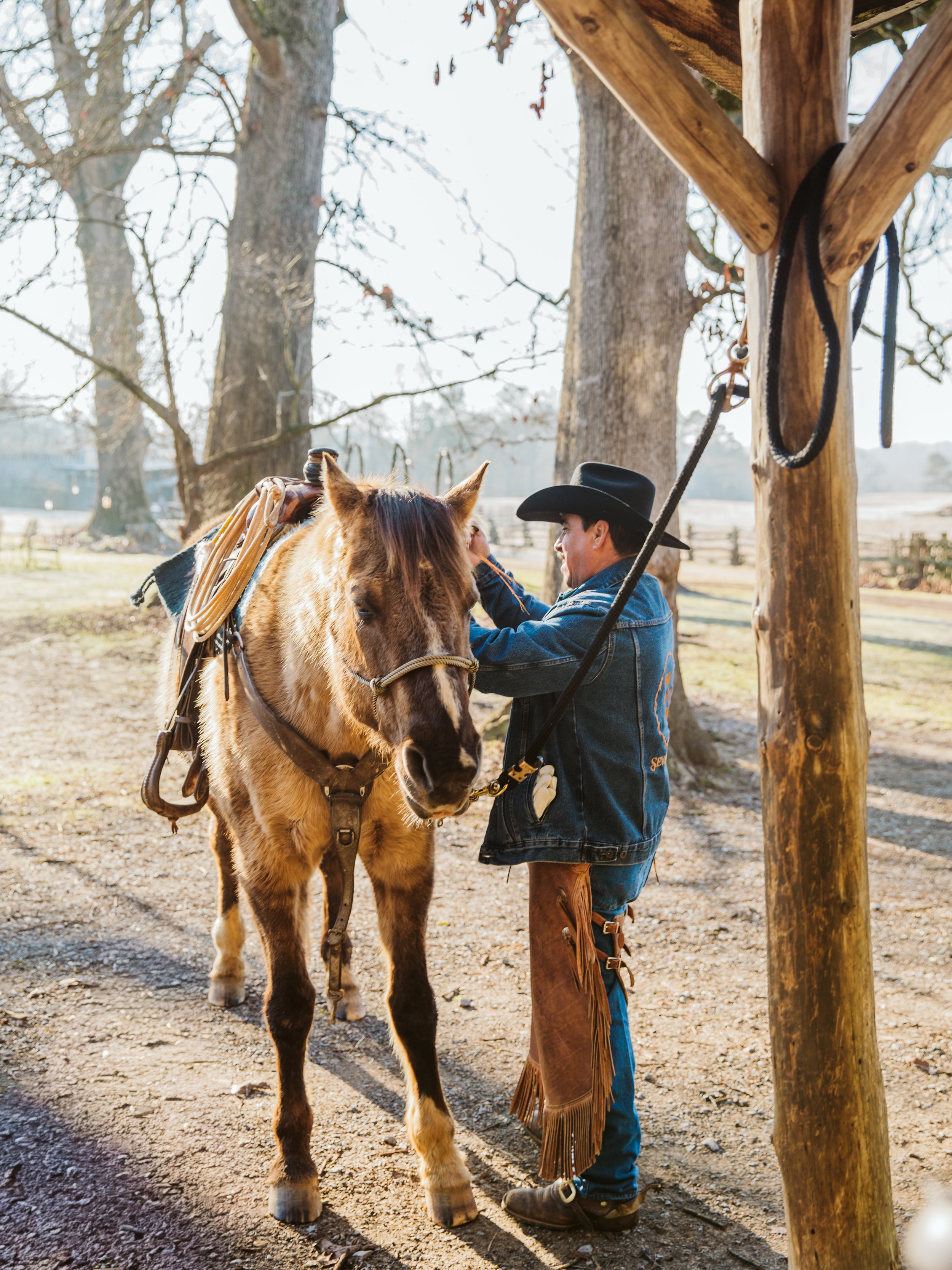 Ranch hand saddling a horse at a North Georgia ranch