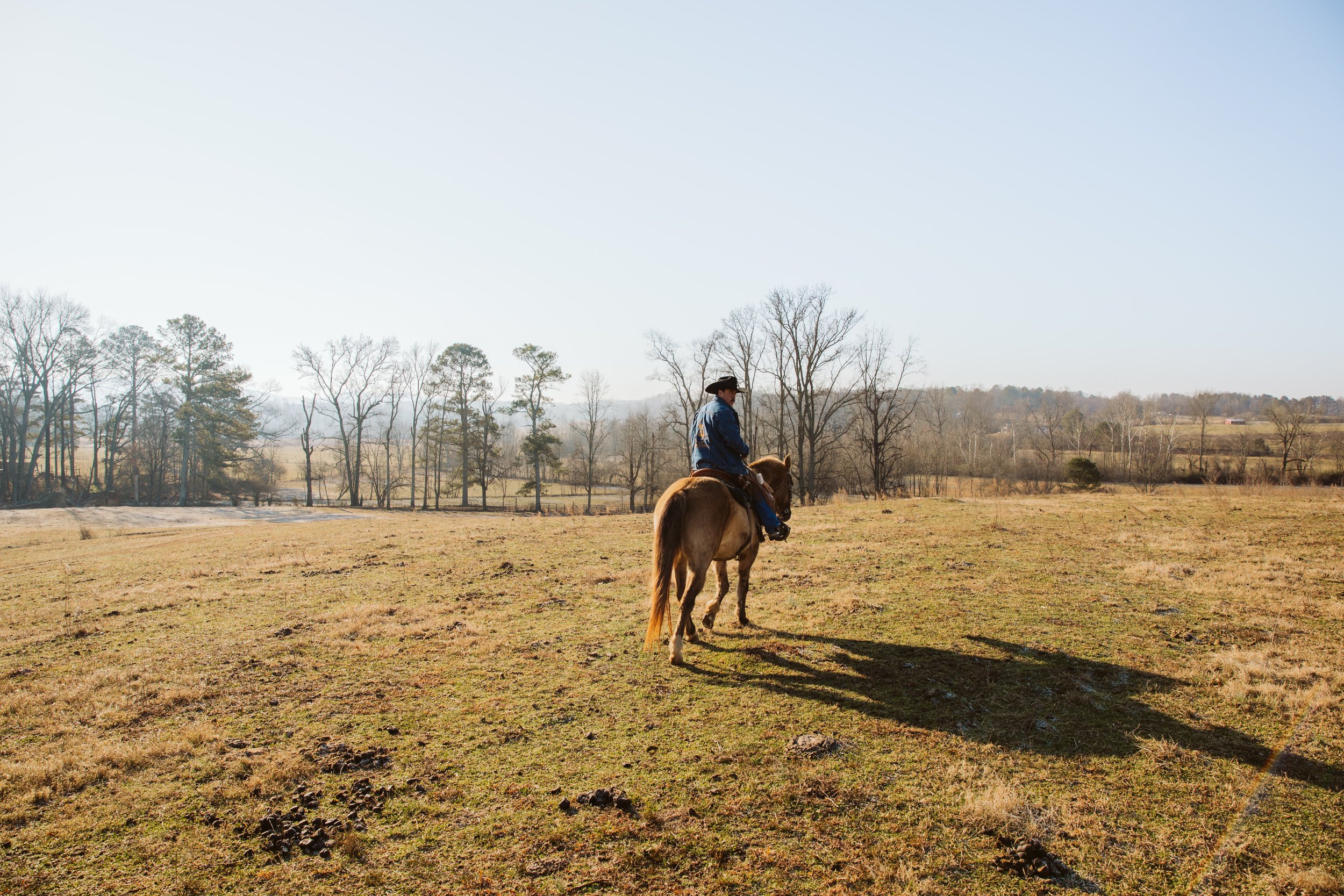 Ranch hands preparing horses outside a barn in North Georgia