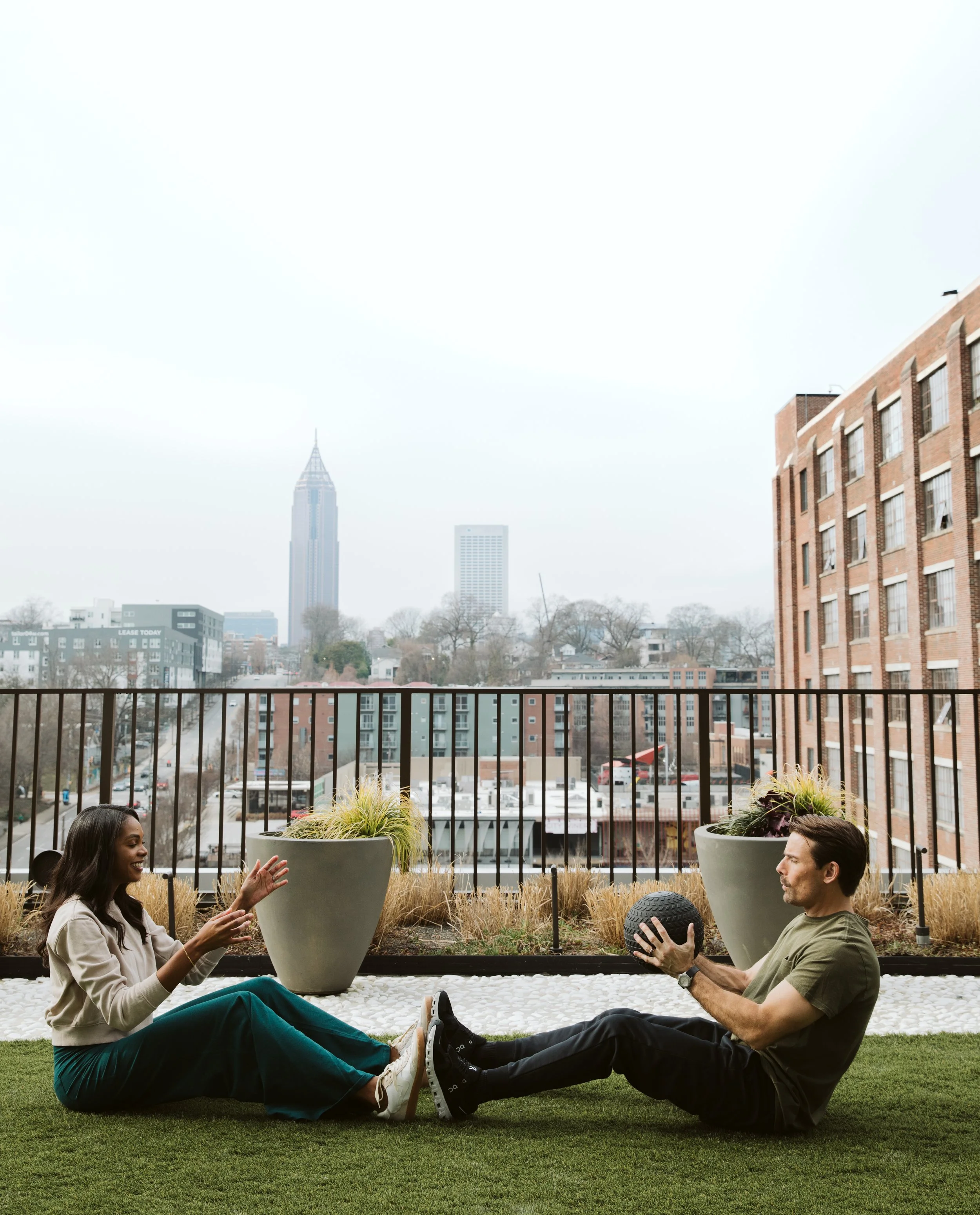 Couple relaxing on rooftop terrace with Atlanta skyline view