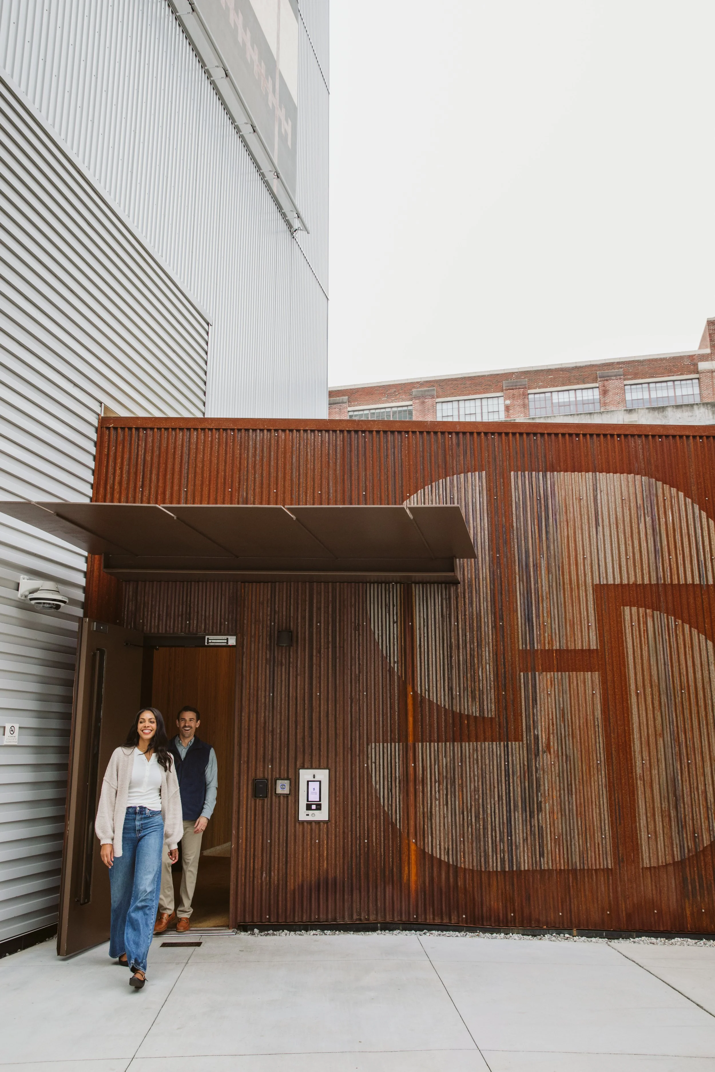 Couple entering modern apartment building entrance