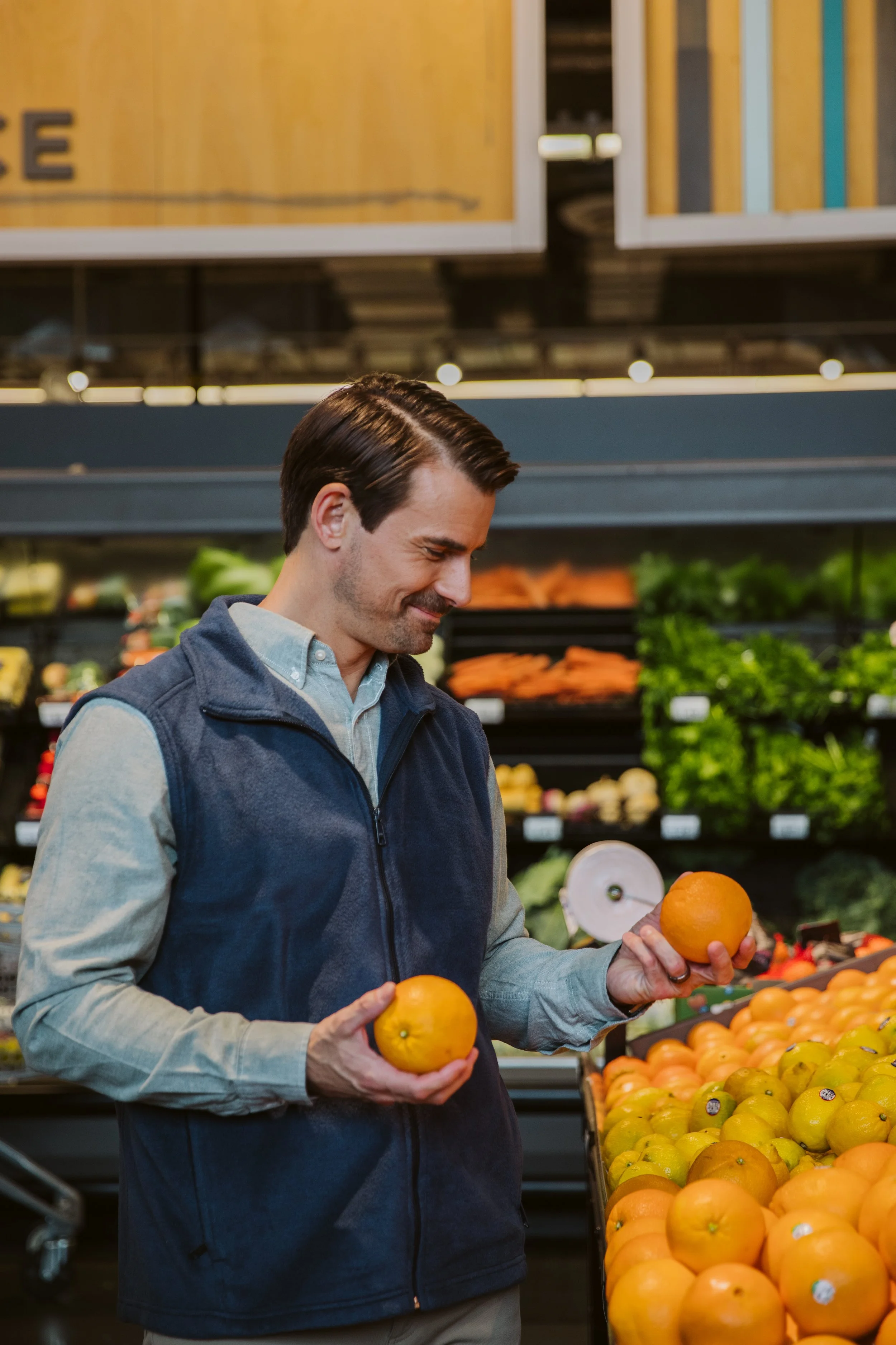 Man selecting oranges at Kroger grocery store