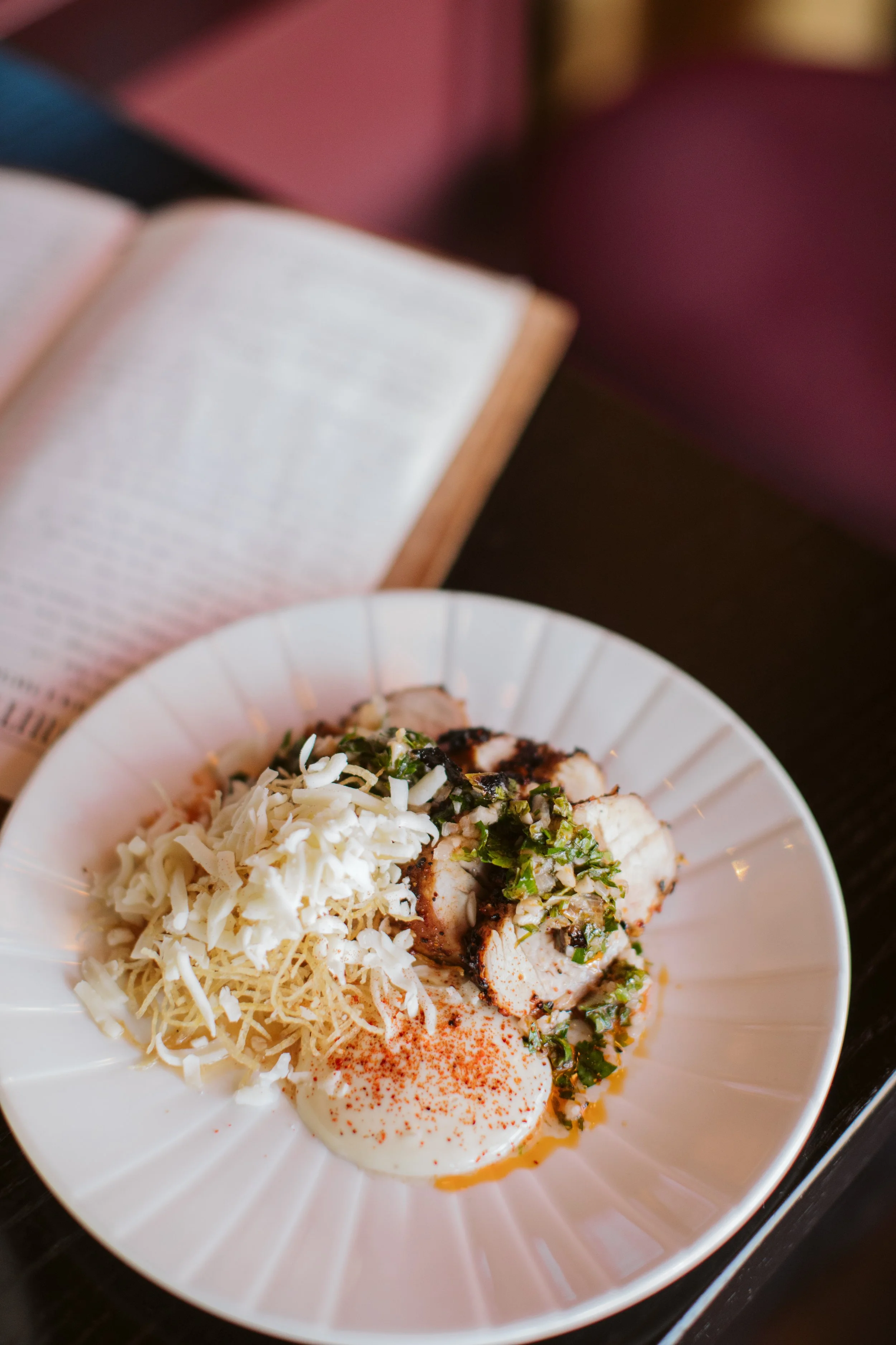 ine dining plated dish with herbs and cheese garnish