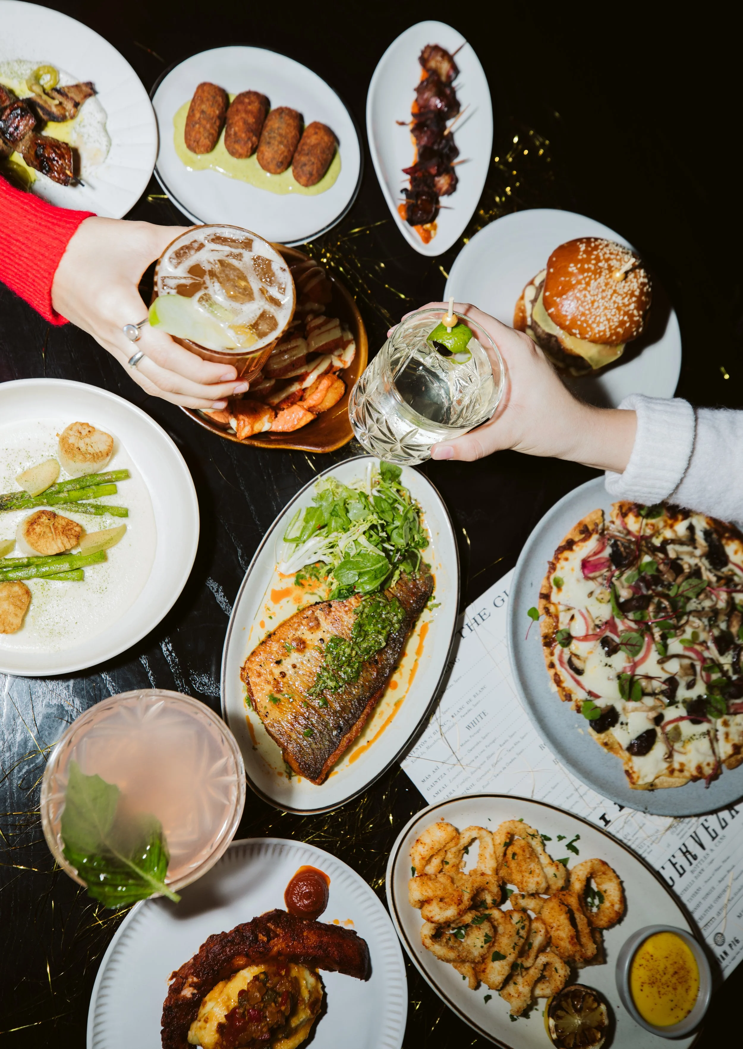 Overhead restaurant table full of dishes and drinks