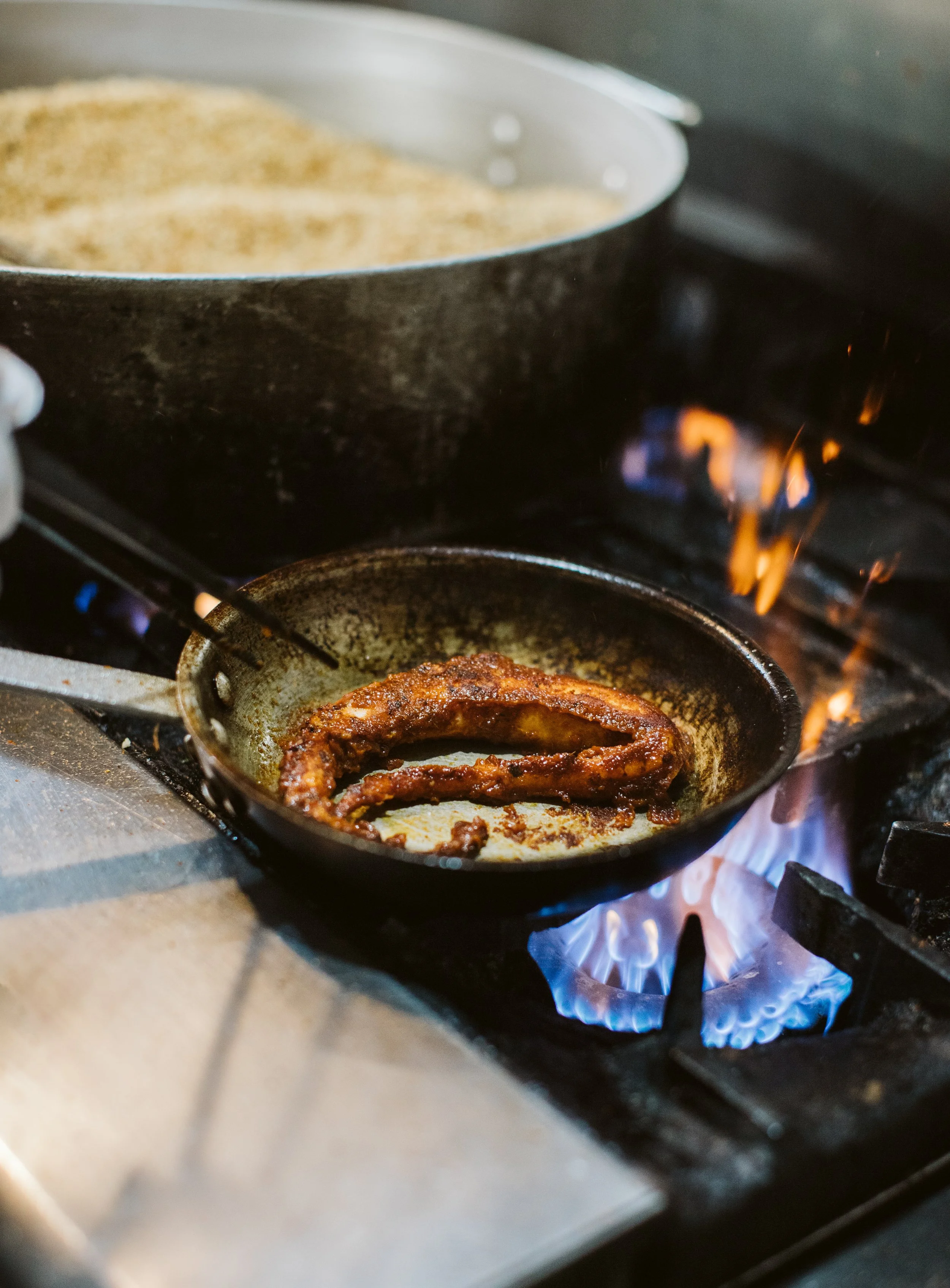 Sausage cooking in skillet on restaurant stove