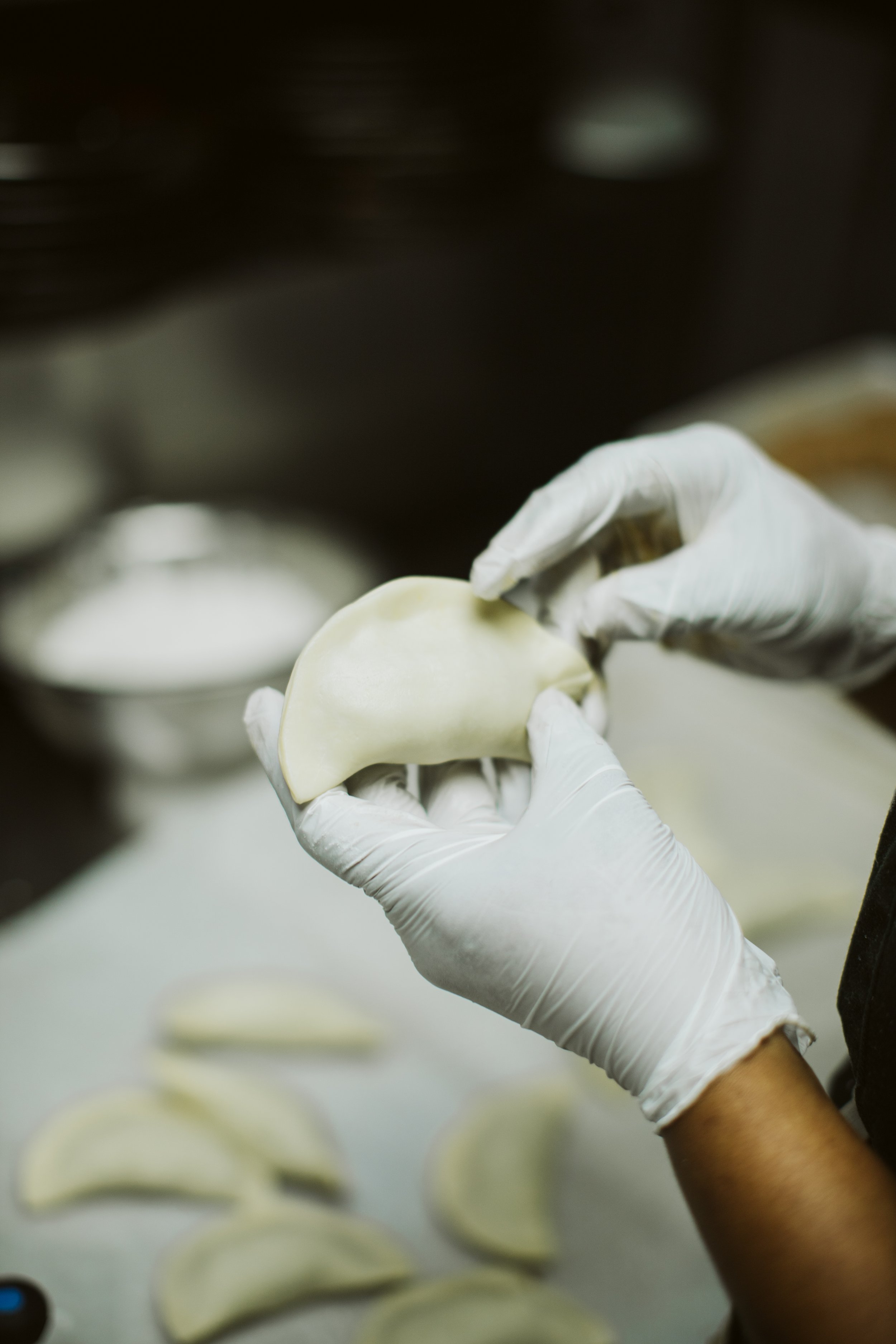 Chef preparing fresh dumplings in restaurant kitchen