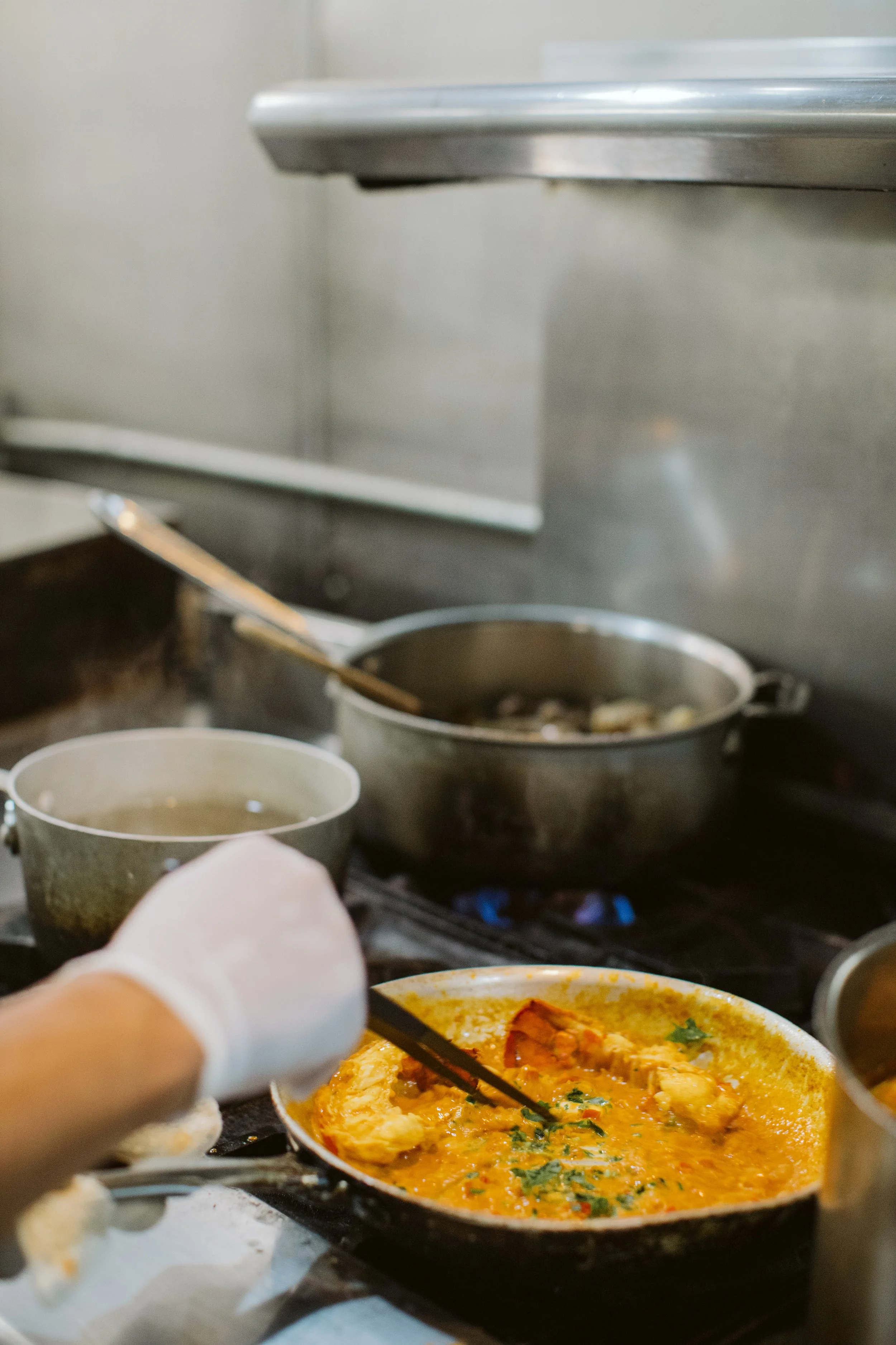 Chef cooking sauce in pan on restaurant stove