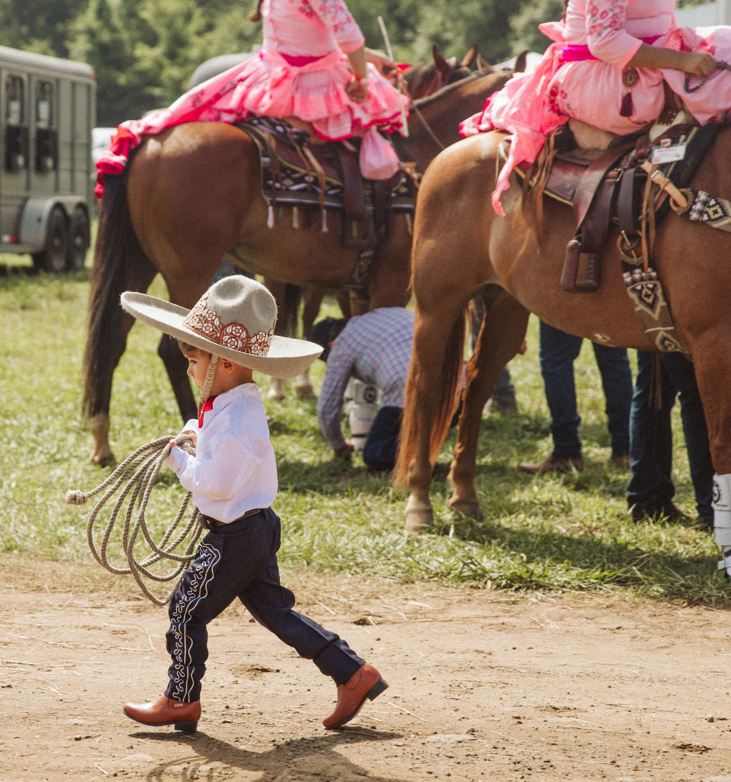 Young cowboy carrying lasso at charreada