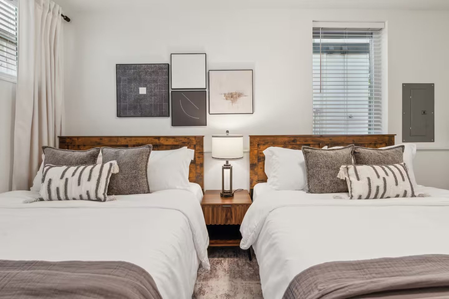 mid century modern designed bedroom with two full-size beds and art