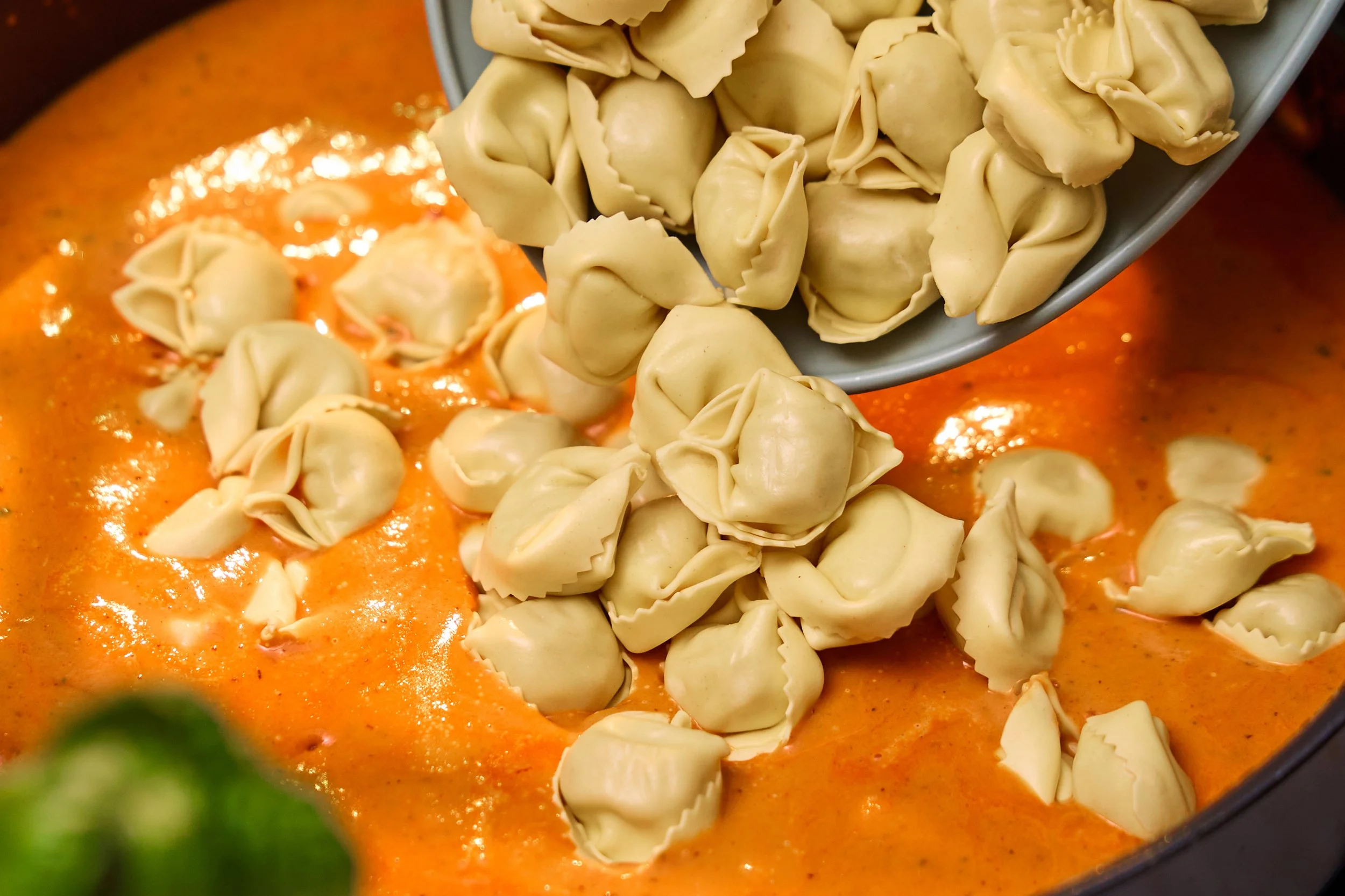 Tortellini blir helt ned i tomatsuppen i gryta