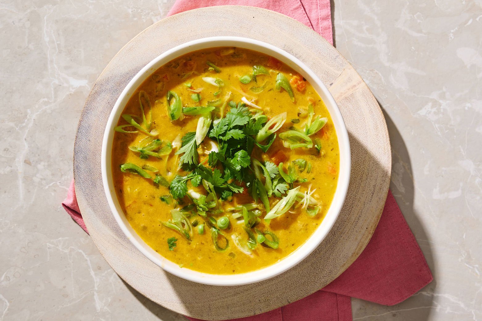 Kyllingsuppe med curry, linser, sukkererter og koriander i en skål