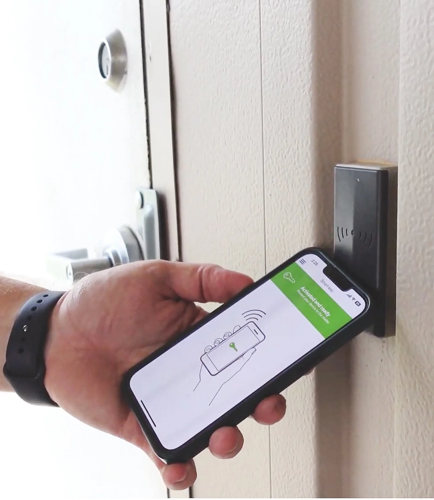 Person using a smartphone with a digital key app to unlock a door.