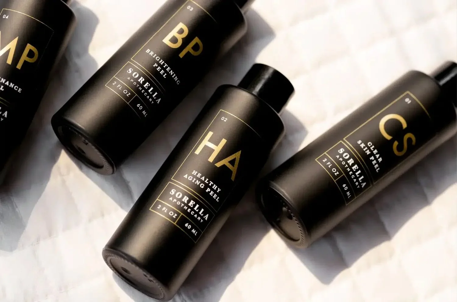 Sorella Apothecary professional chemical peel bottles displayed in soft natural light, featuring brightening, healthy aging, and clear skin peel formulas used during winter peel season.