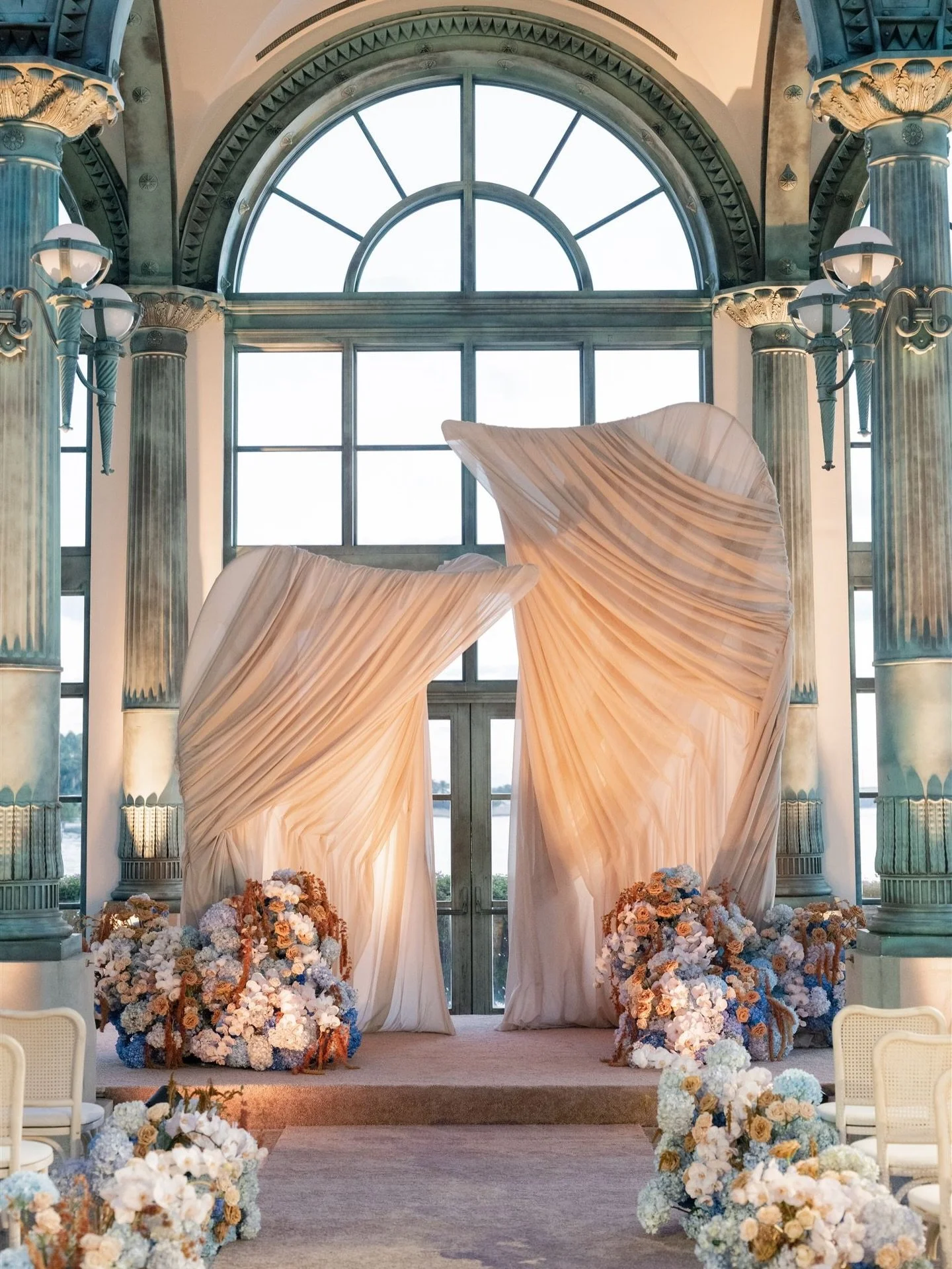 Built for a single breath. Meant to last forever.
Within the grandeur of a Gilded Age museum, thirteen feet of ivory silk rose into sculptural form, draped and shaped to evoke wind in motion, as if the fabric itself had exhaled. Soft curves and sweep