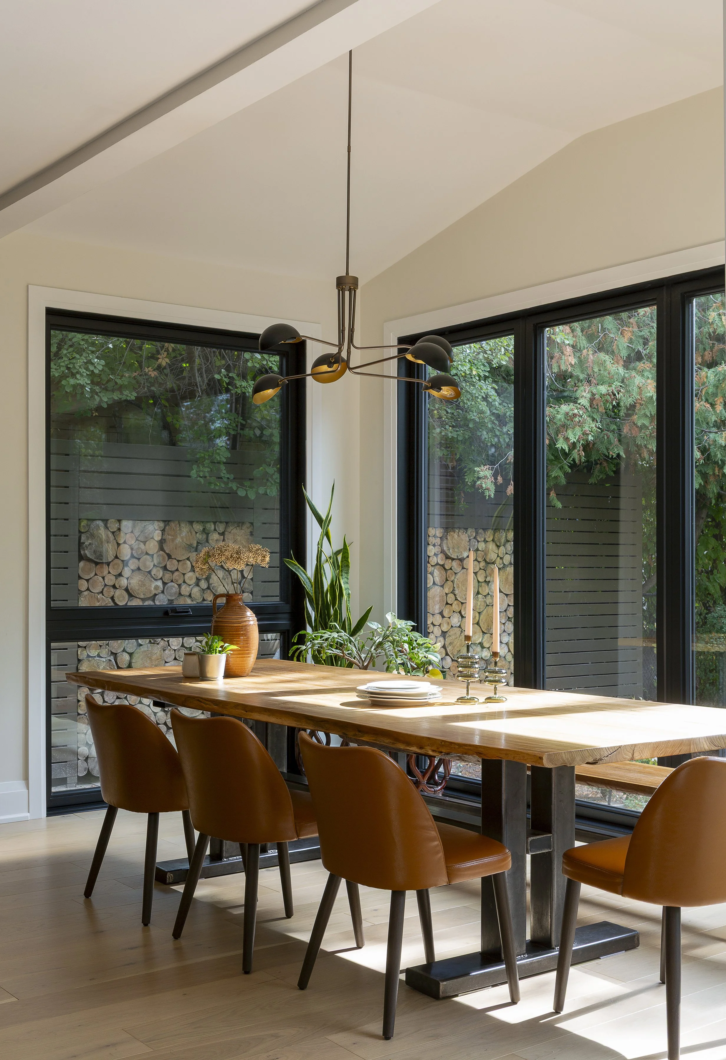 Light-filled dining room designed by Intrinsic Studio Collective with natural views and a warm, calming interior.