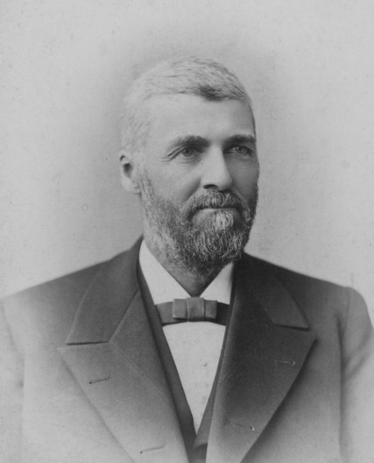People shoveling snow in front of a multi-story building during winter.