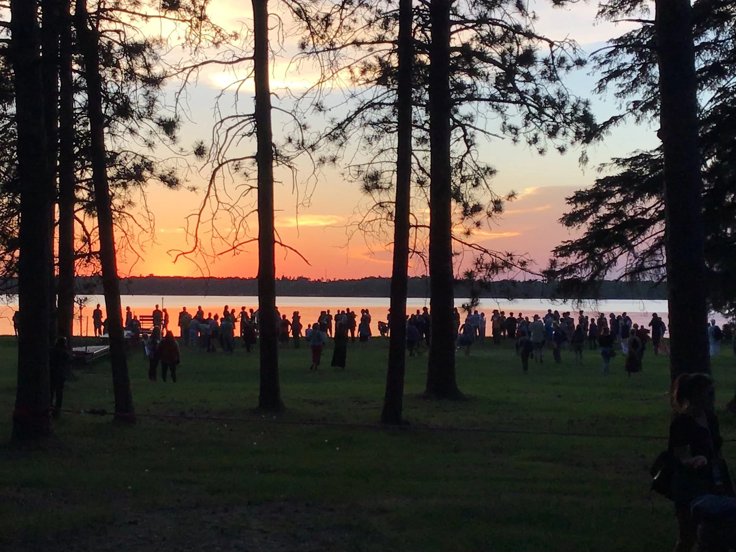Treaty People Gathering. Multi-faith group blessing the water at sunset
