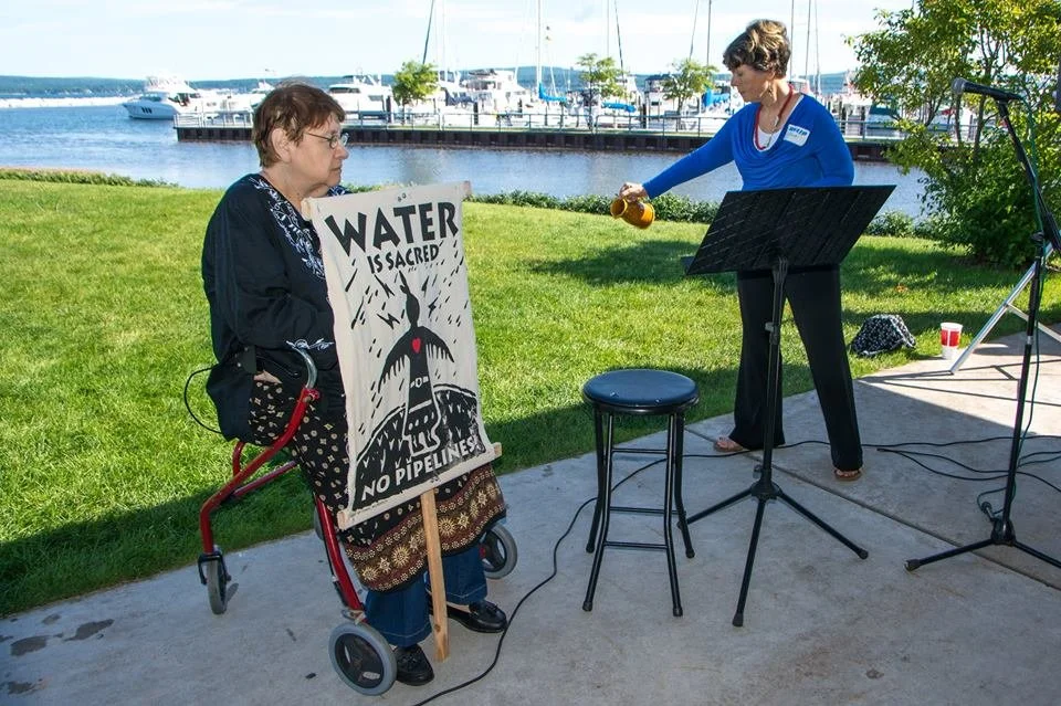 Deb pouring a libation for Flint at an event in Petoskey.