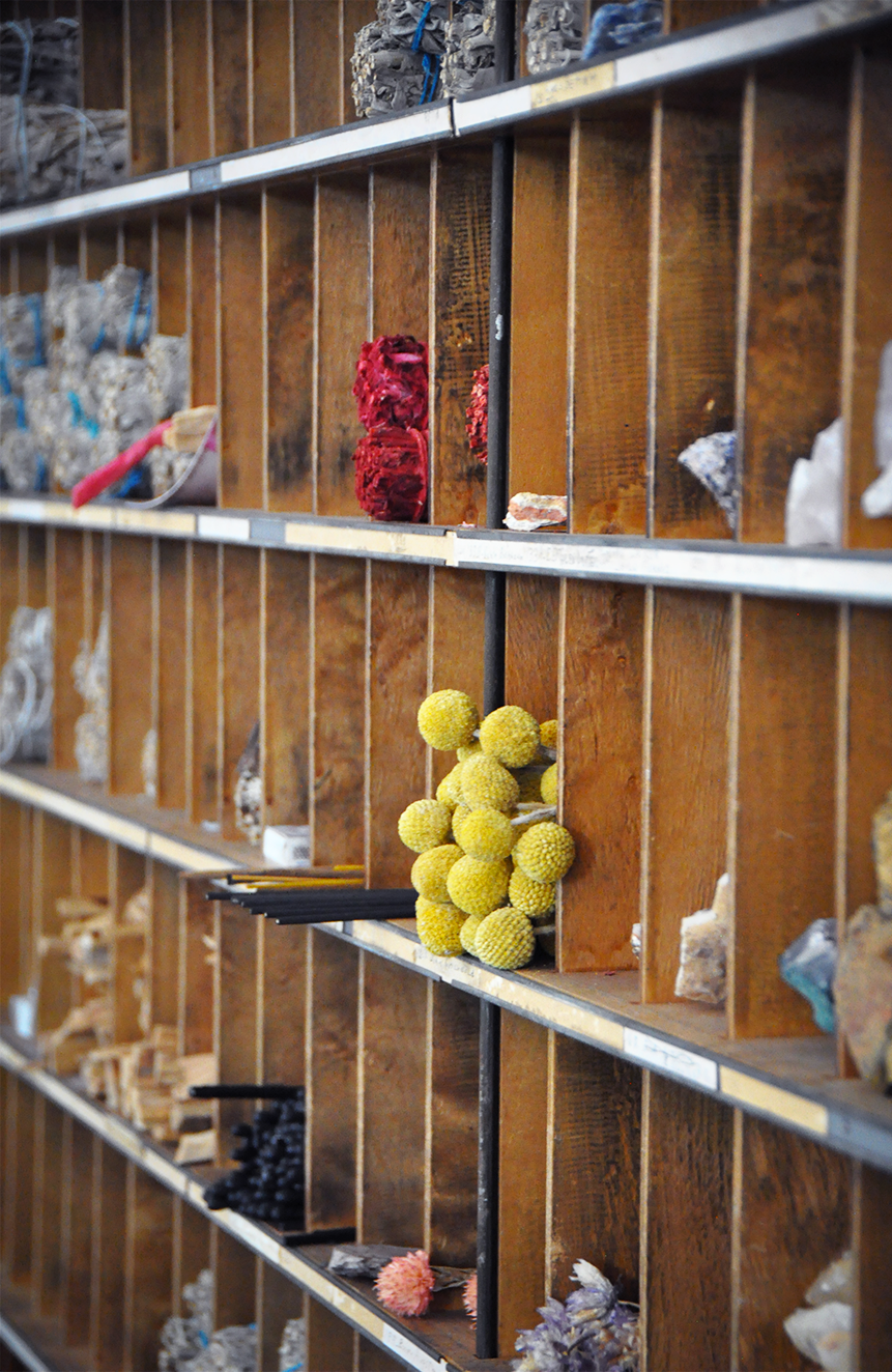 Wooden storage cubbies holding various rocks and minerals, with yellow spherical mineral specimens in the middle