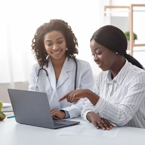 Hair loss consultation for traction alopecia — female specialist in medical attire discusses personalized treatment plan with client in bright wellness office.