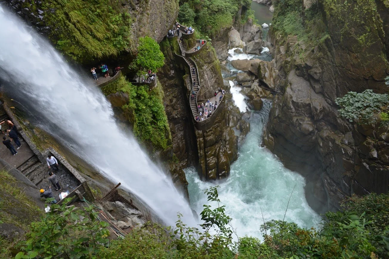 Vista de uma cachoeira com escadas e passarelas de observação, muitas pessoas admirando a paisagem e a força da água.