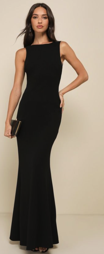 A woman in a black sleeveless, floor-length gown holding a small gold clutch purse.