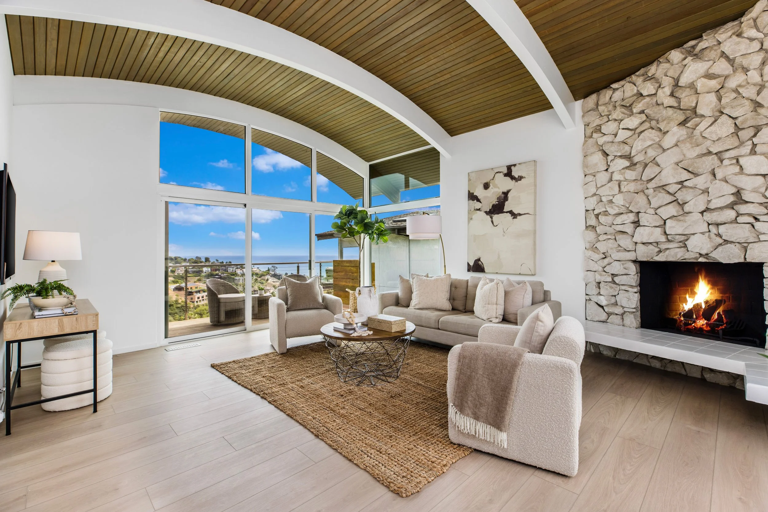 Ocean view living room with floor to ceiling windows, a gas starter wood burning fire place and terrace for entertaining