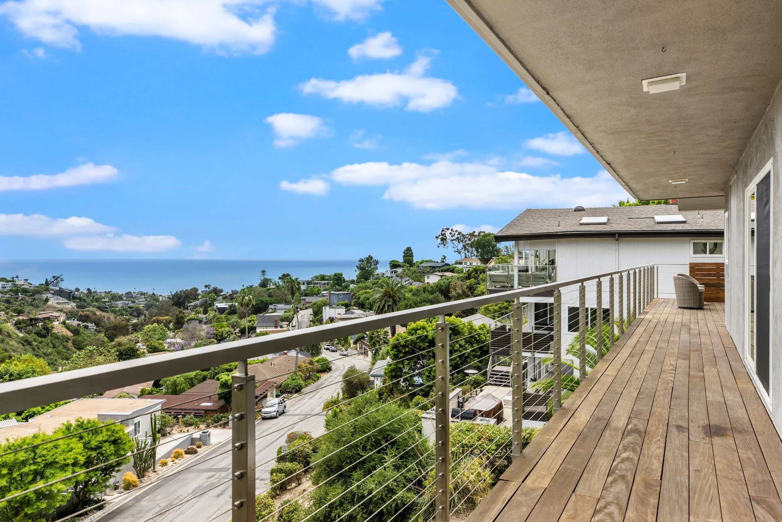Ocean view balcony stretches the entire length of the top level of the home. Sliding glass doors from the living room, dining room and main floor bedroom step out onto this wonderful entertaining space perched above the ocean.