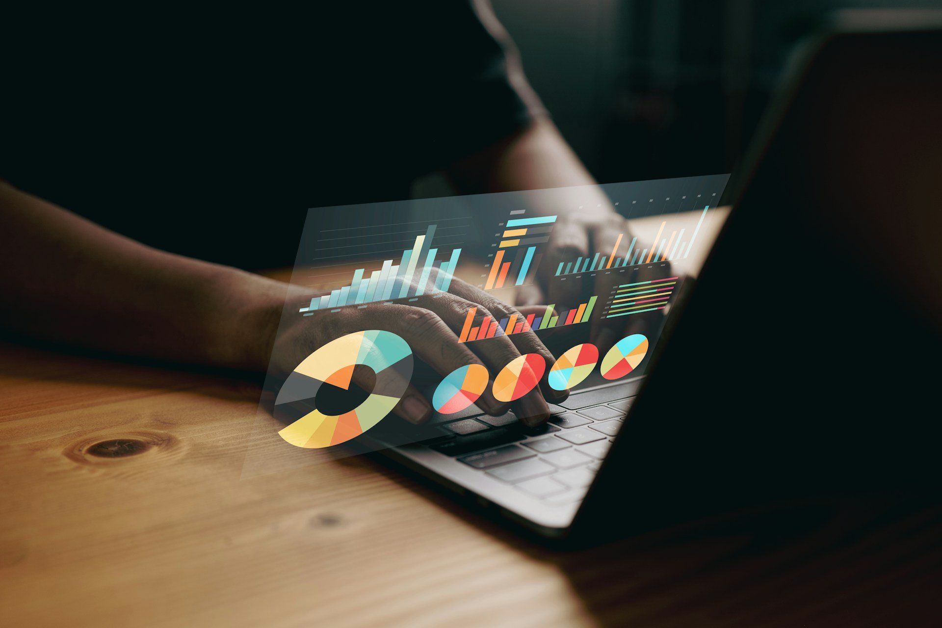 Hands on a laptop with holographic charts and pie graphs—visualizing Excel skills for accountants like PivotTables, SUMIFS/COUNTIFS, LOOKUPs, and audit-ready reporting.