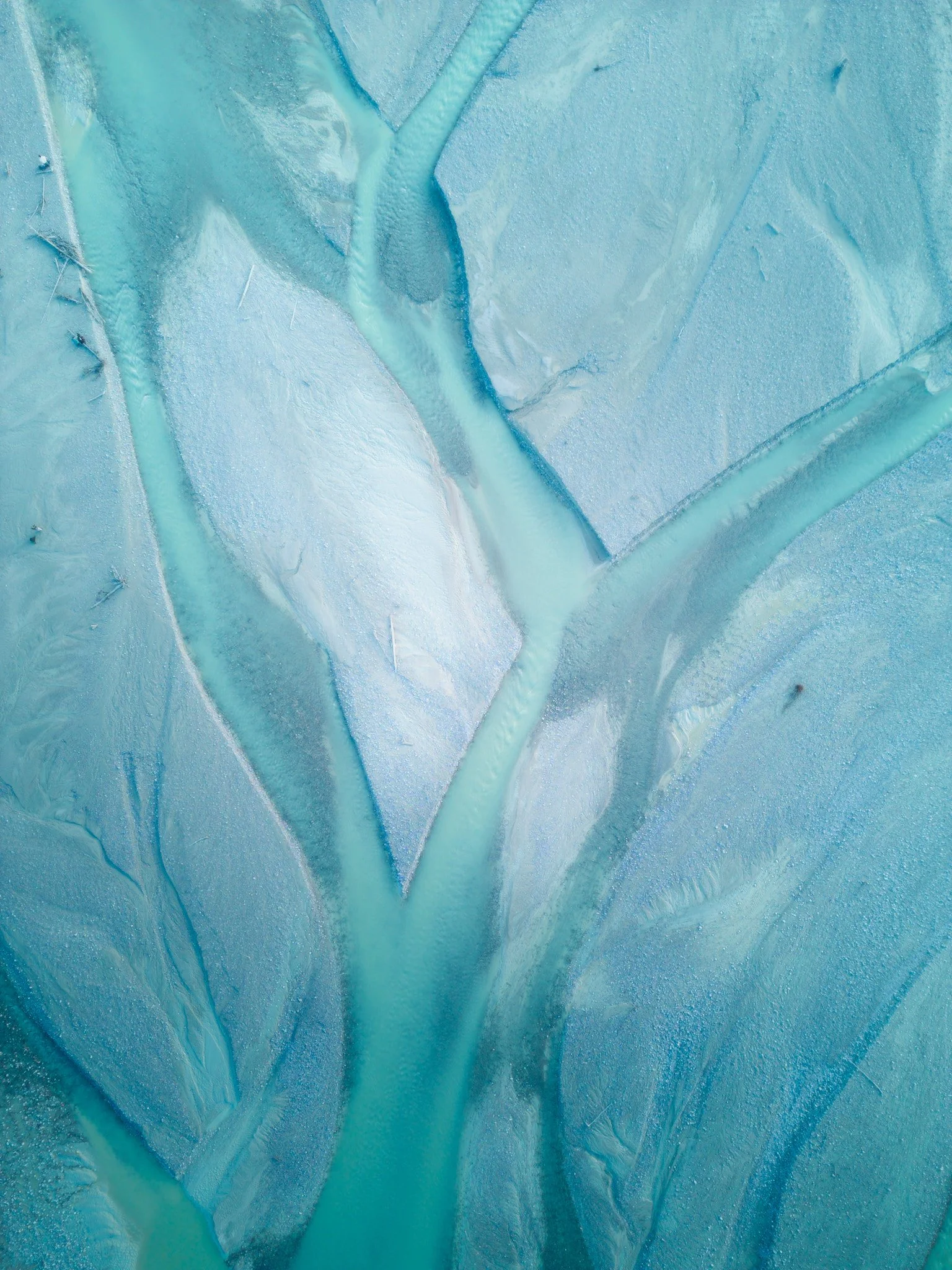 Close-up of a blue ice sheet or glacier with cracks and textures.