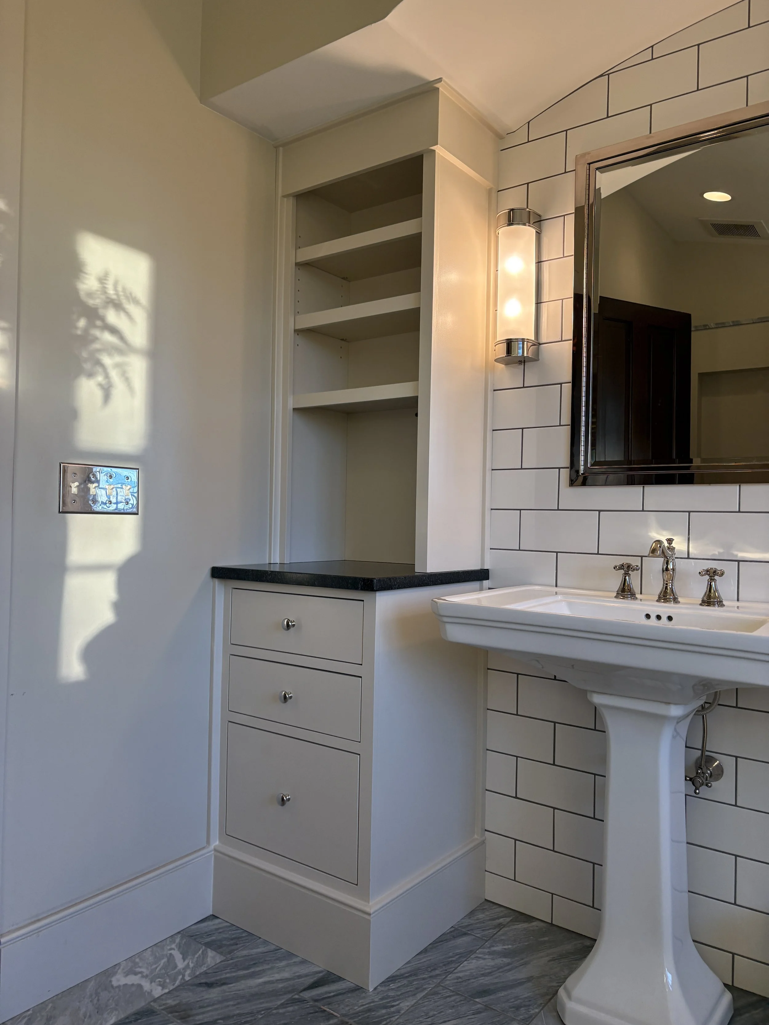 white cabinets in a subway tiled bathroom